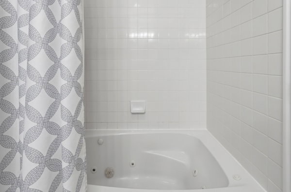 White tiled shower surround with a built-in jetted tub