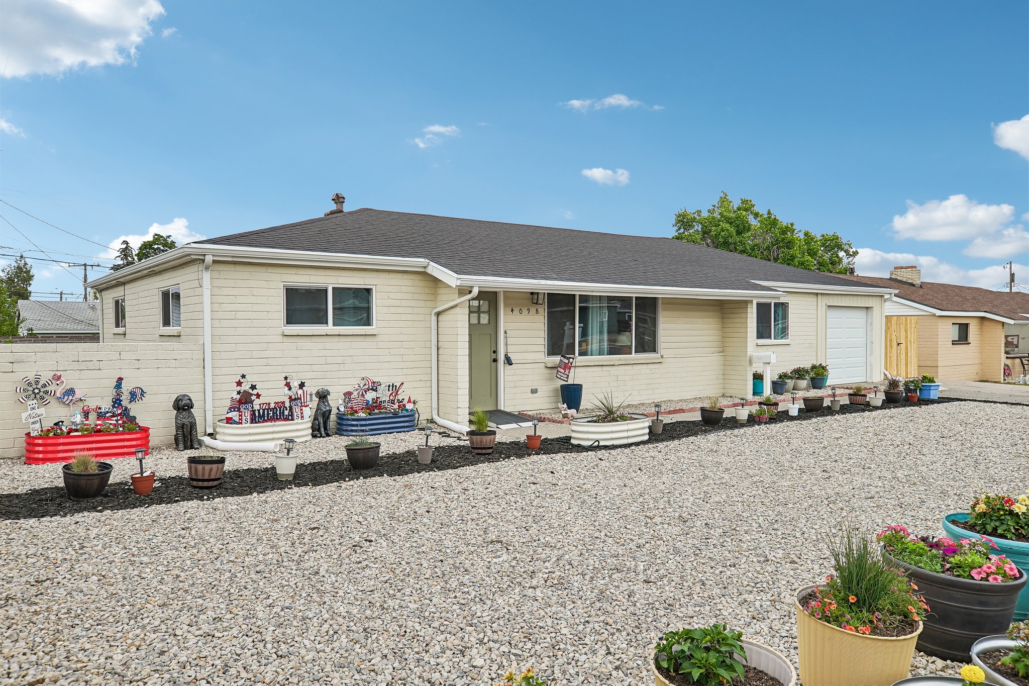 Ranch-style exterior with light-colored siding, a dark roof, and white window trim