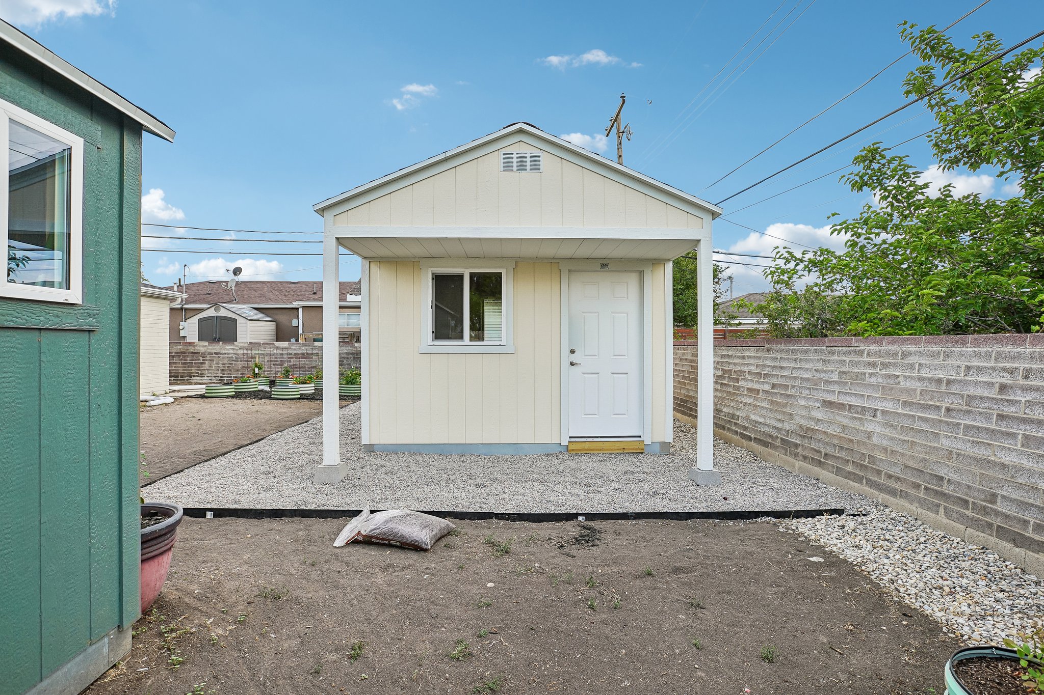 Detached utility building featuring horizontal siding, a covered entry, and a white paneled door