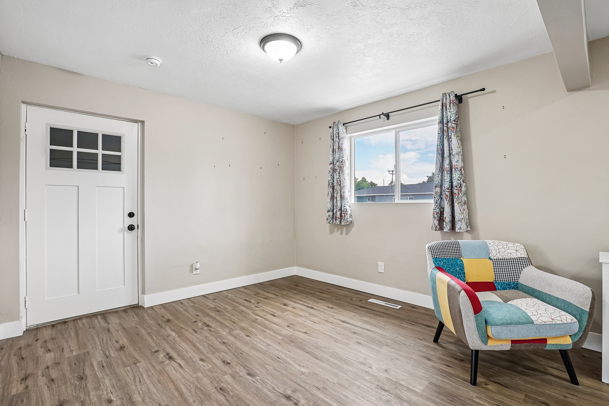 Laminate wood-finish flooring complements the neutral wall color