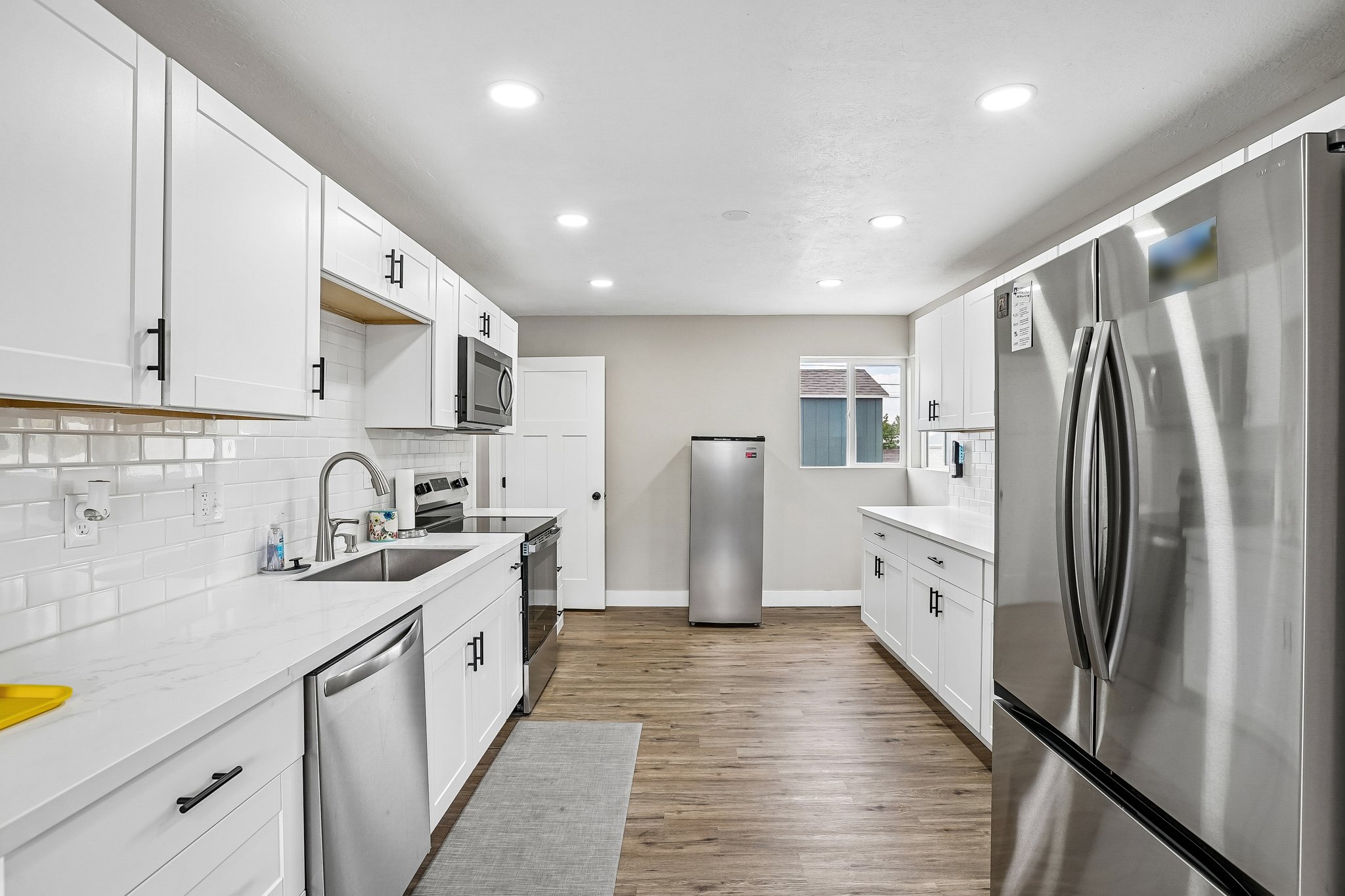 Modern kitchen with white cabinetry and stainless steel appliances