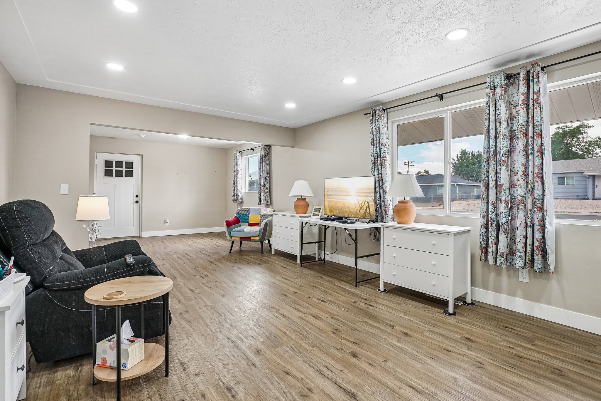Spacious living area featuring wood-finish flooring, recessed lighting, and expansive windows