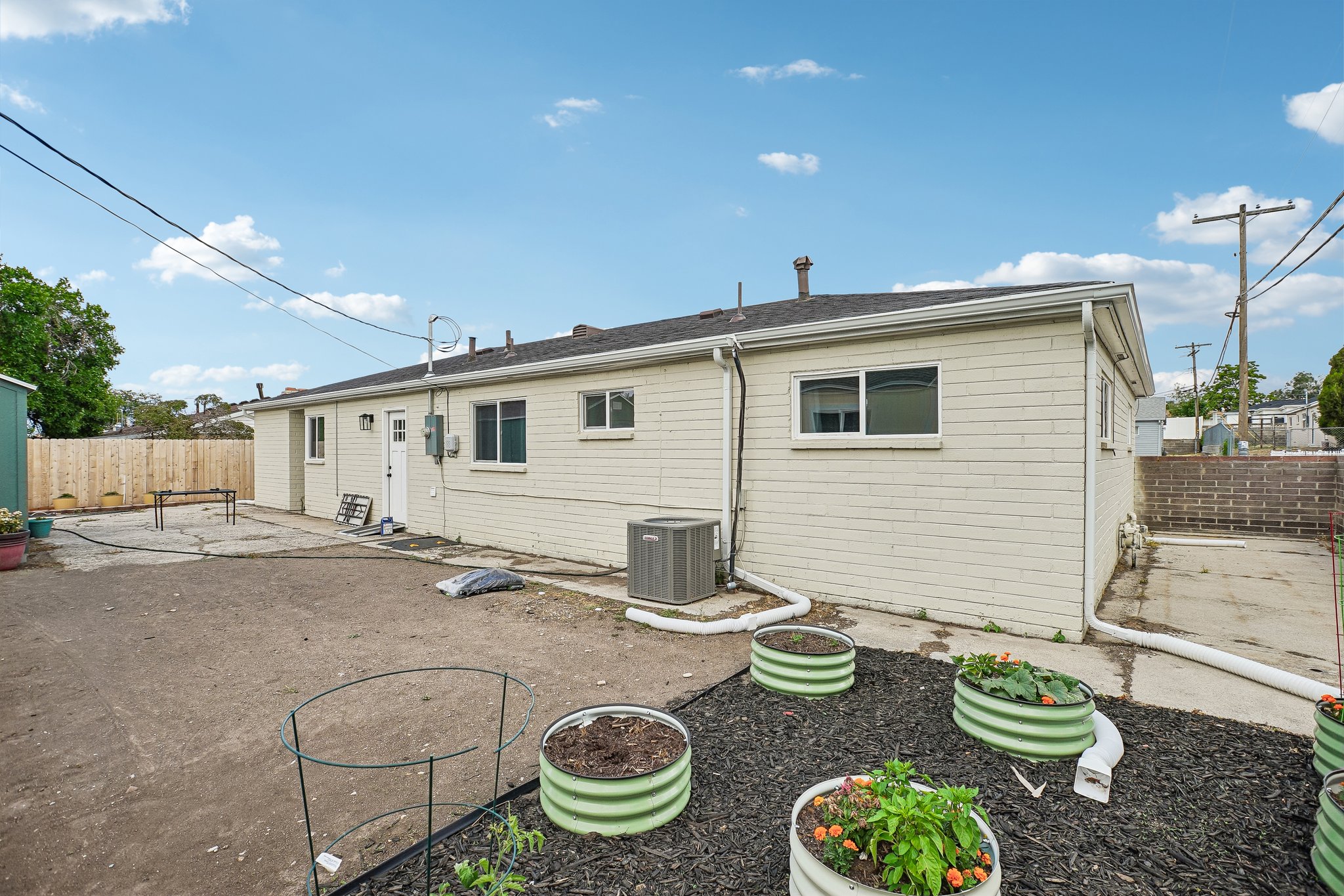 Rear exterior featuring a durable shingle roof, light-colored brick siding, and multiple windows