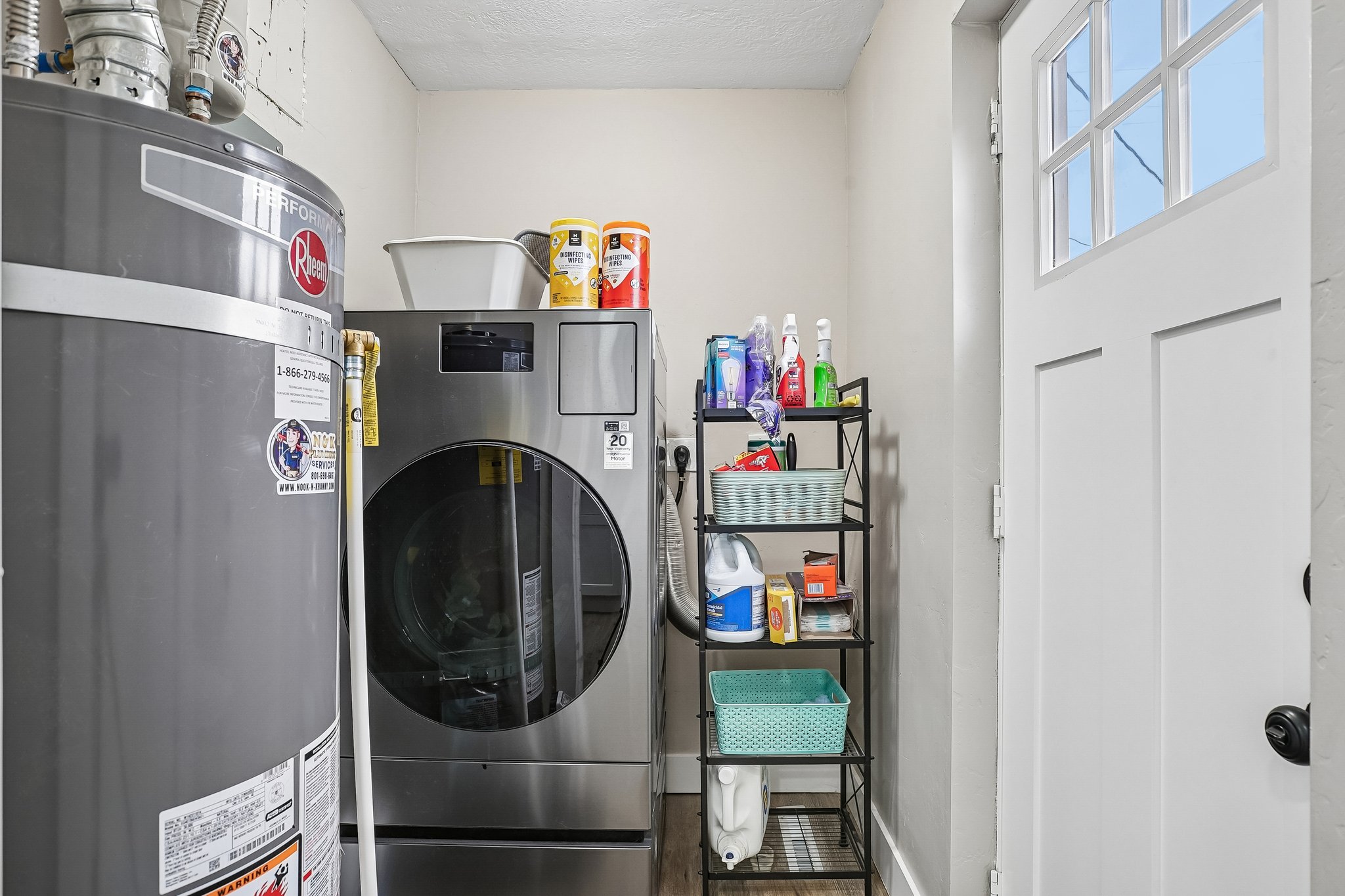 Dedicated utility area featuring a water heater and stainless steel washer and dryer units
