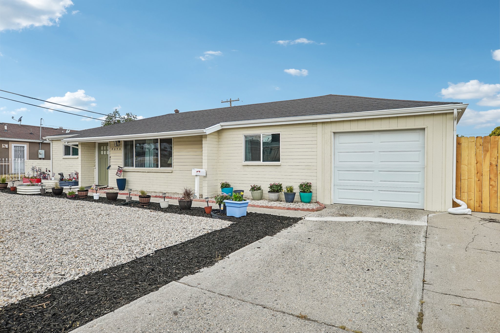 Single-story residence featuring light-colored siding and a dark shingle roof