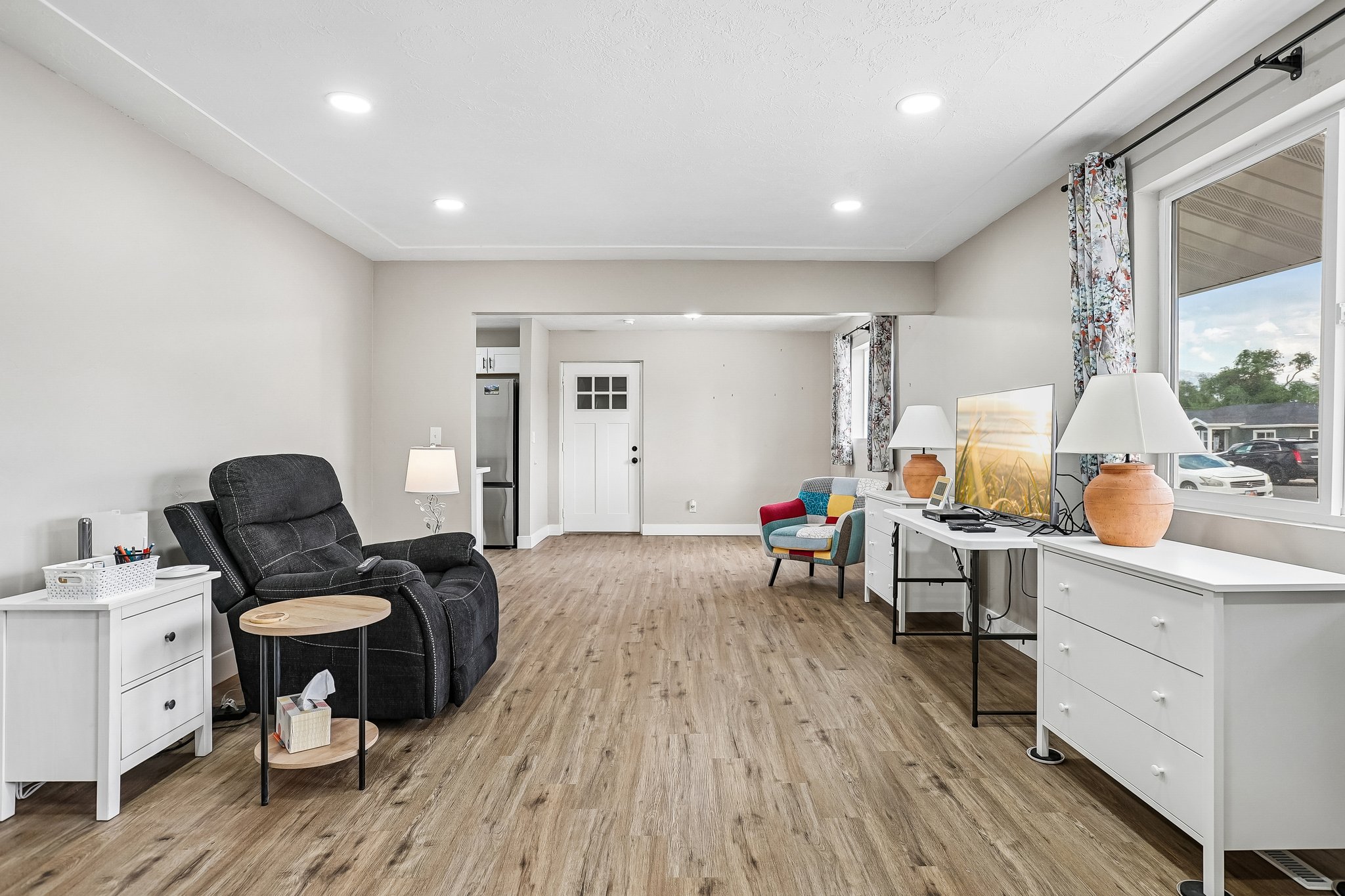 Spacious living area featuring wood-finish flooring, recessed lighting, and light-toned wall paint