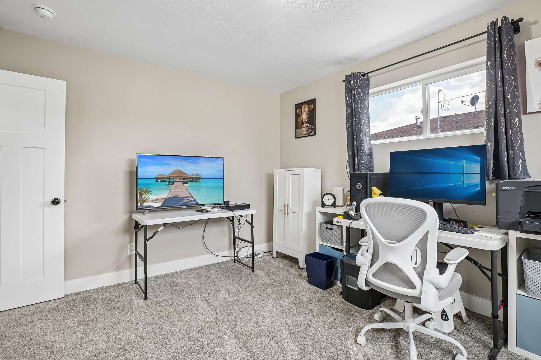 Neutral tone wall paint, plush carpeting, a white two-panel interior door, and a white window frame with a single pane