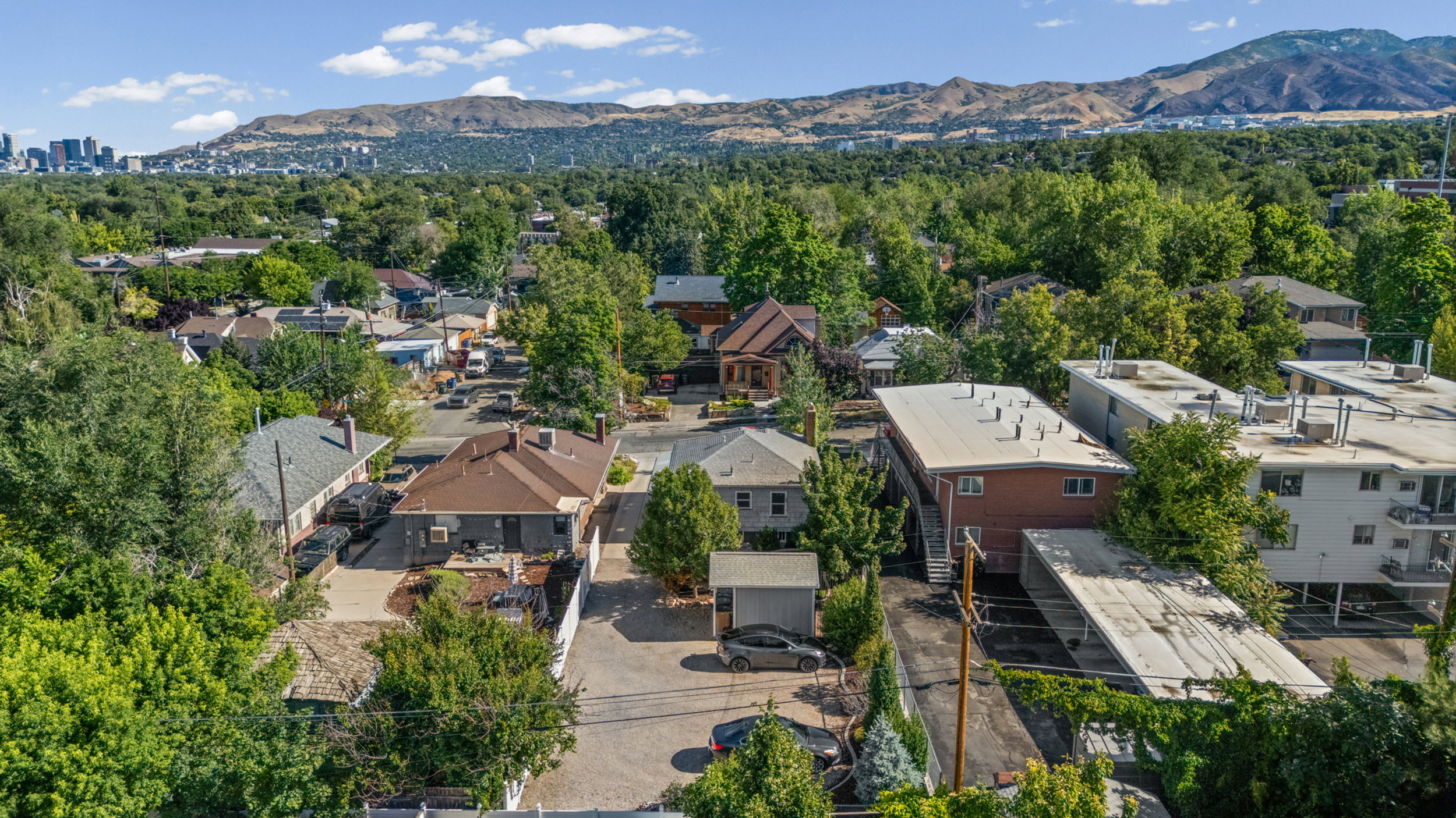 Aerial perspective showcasing a residential neighborhood with a distant city skyline and mountain range