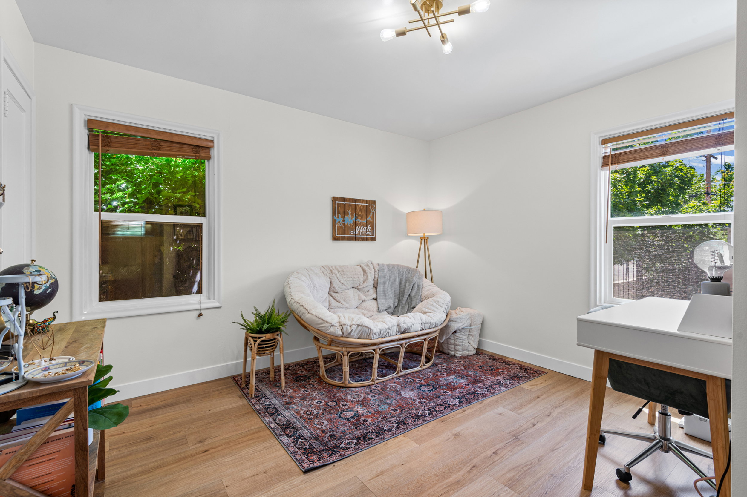Room featuring light wood-finish flooring, white walls, and a modern ceiling light fixture