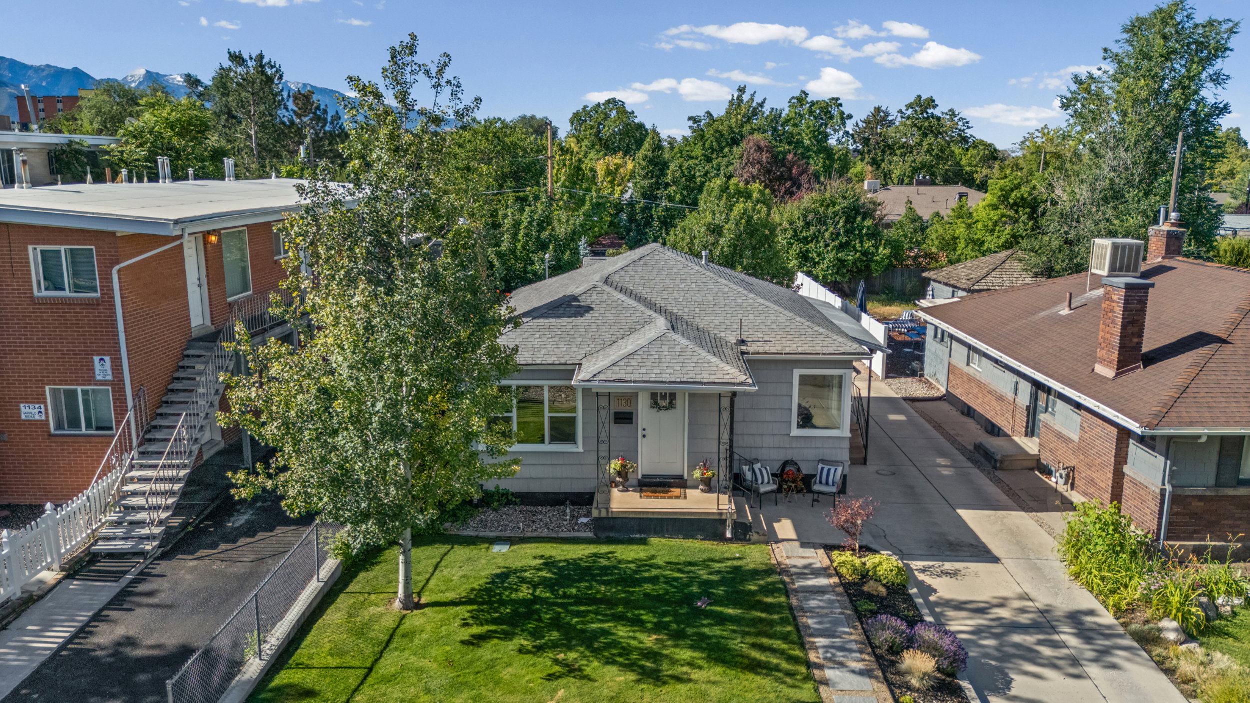 Single-story residence featuring a front porch, a well-maintained lawn, and established landscaping