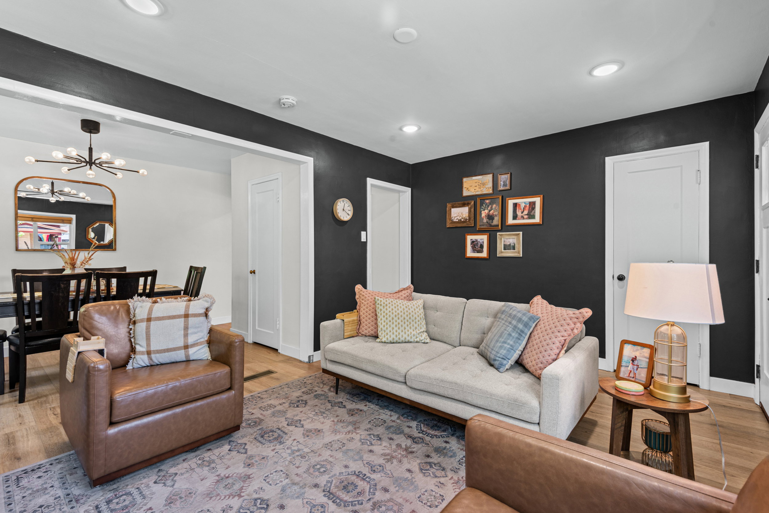 Living area featuring wood-finish flooring, recessed lighting, and a dark accent wall