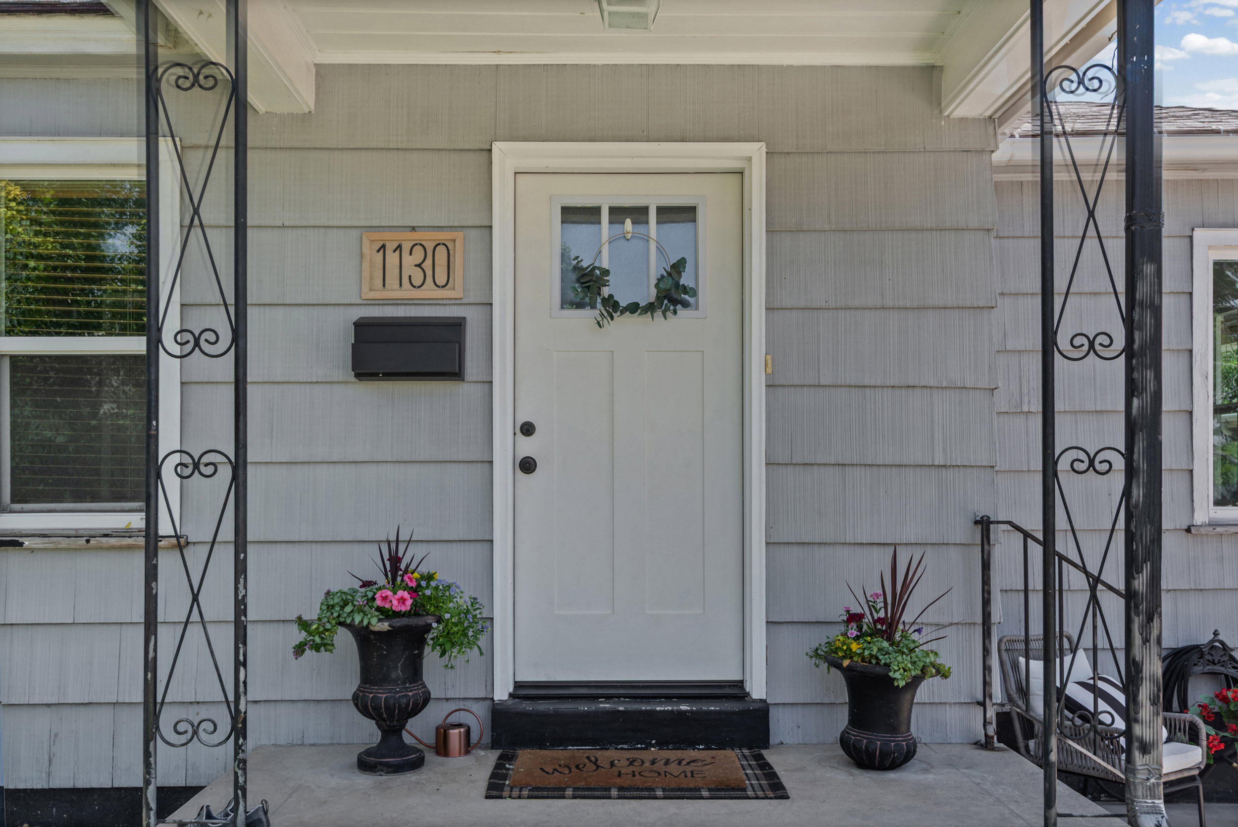 Inviting front entrance featuring a light gray exterior siding and a white paneled door with glass inserts