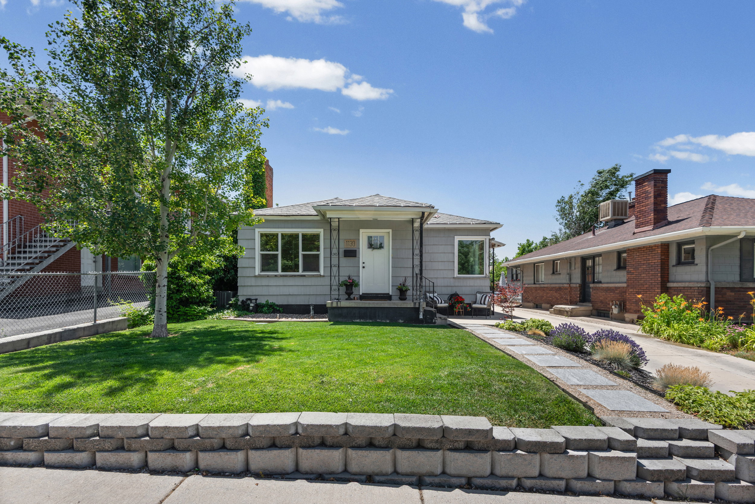Charming single-story residence featuring light gray siding and a complementary white trim