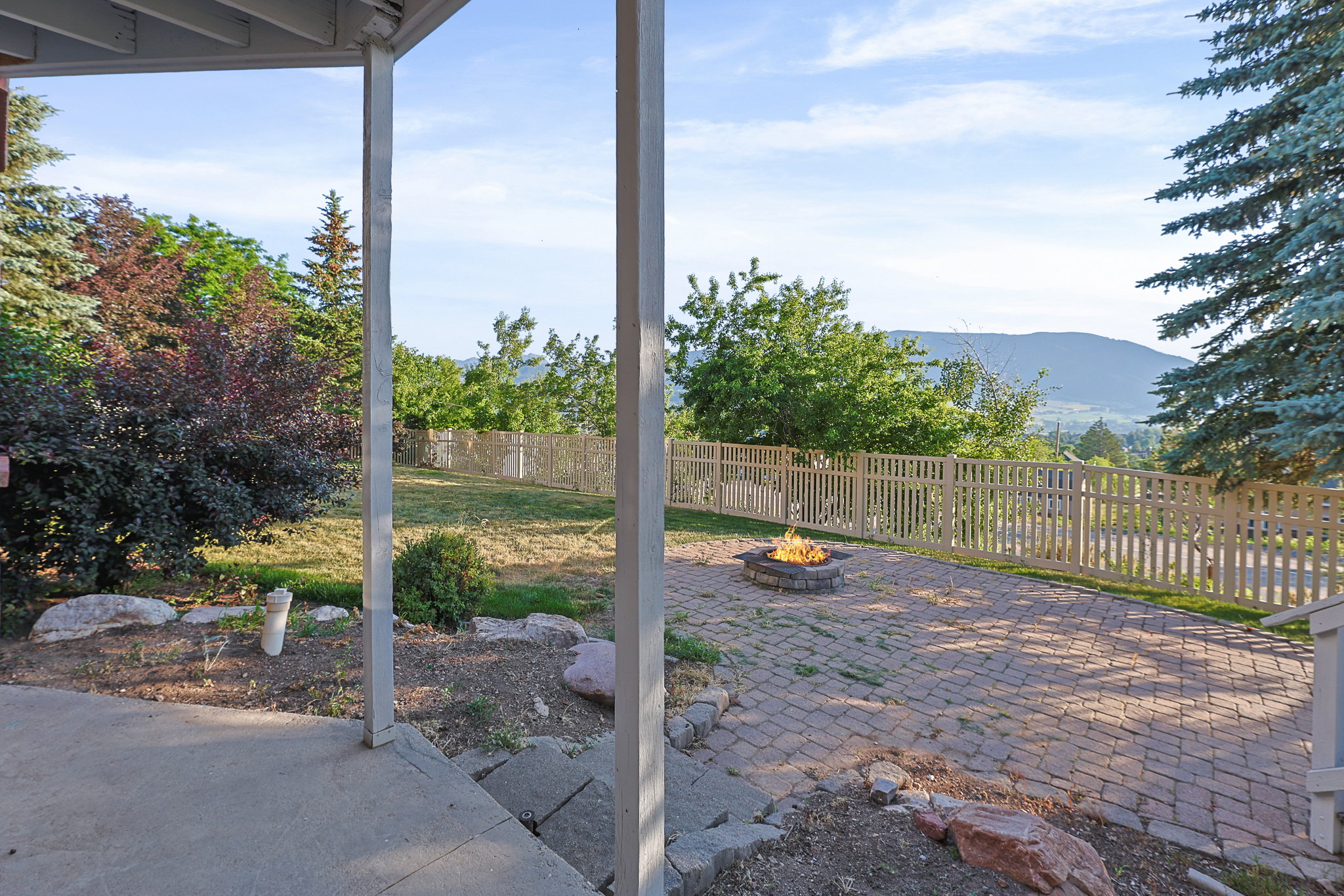 Hardscaped paver patio featuring a stone fire pit