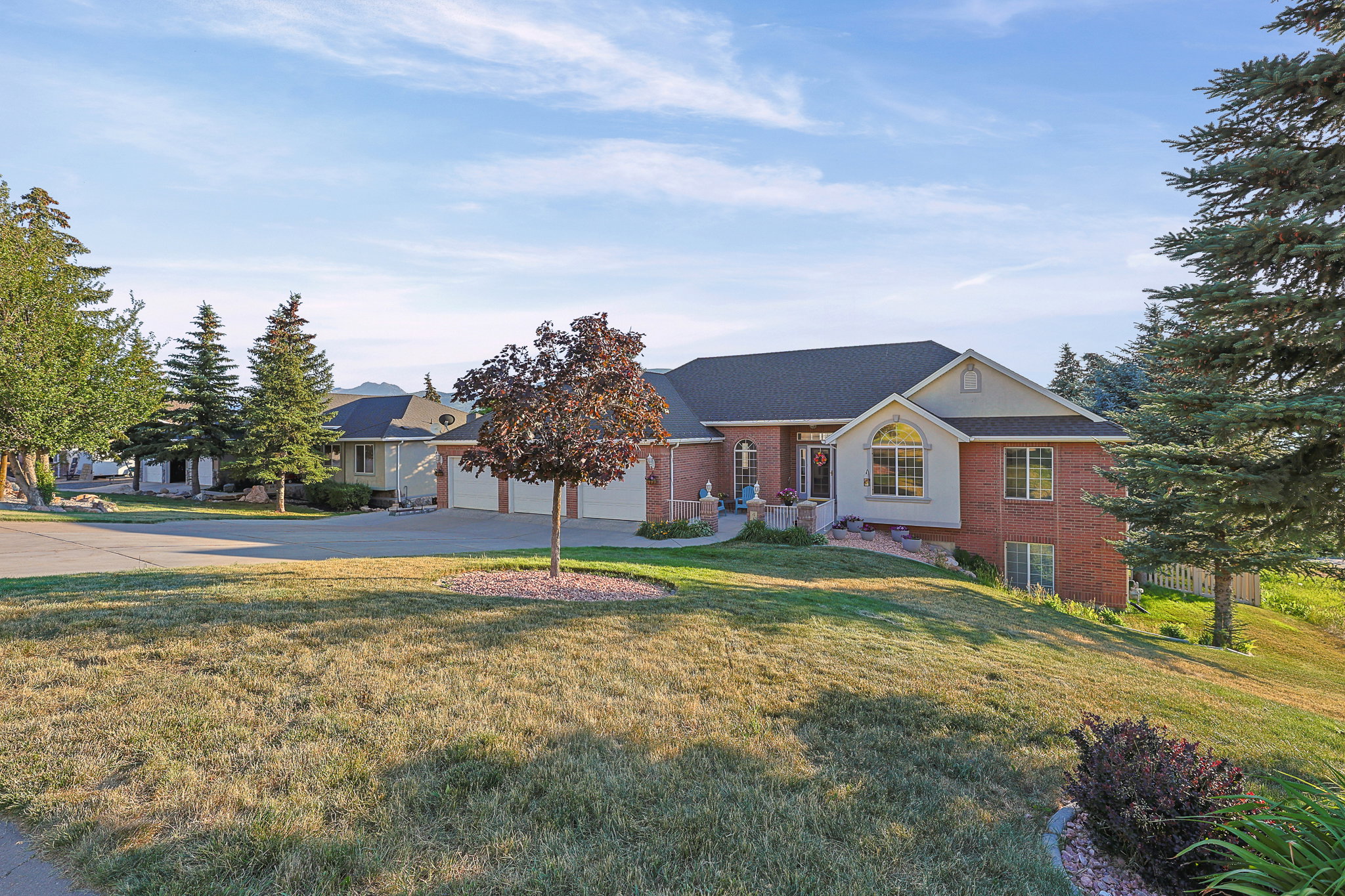 Brick and siding exterior featuring an arched window, a prominent front entrance, and an attached multi-car garage