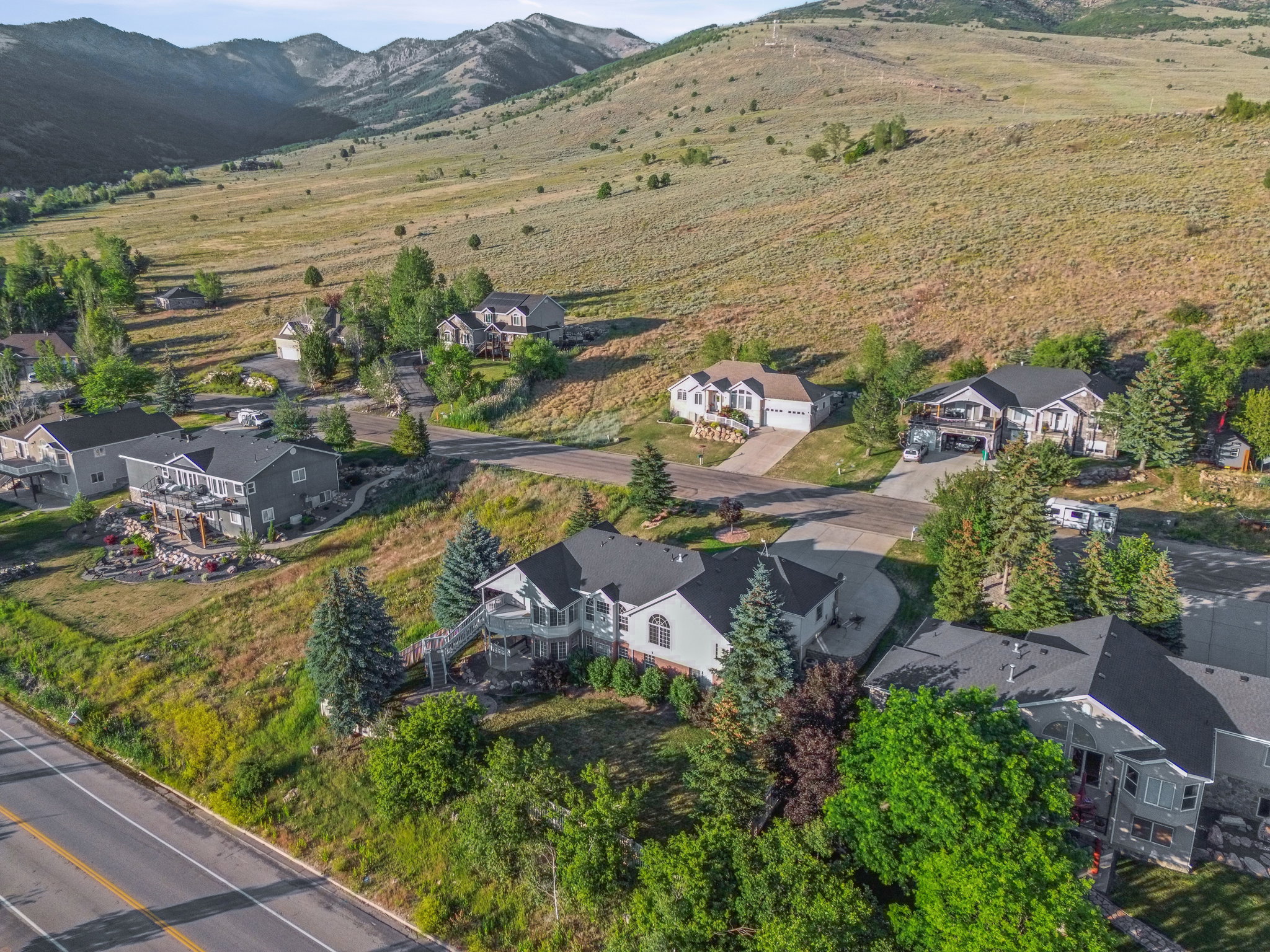 Residential properties nestled into a sloping hillside, featuring diverse architectural styles and mature landscaping