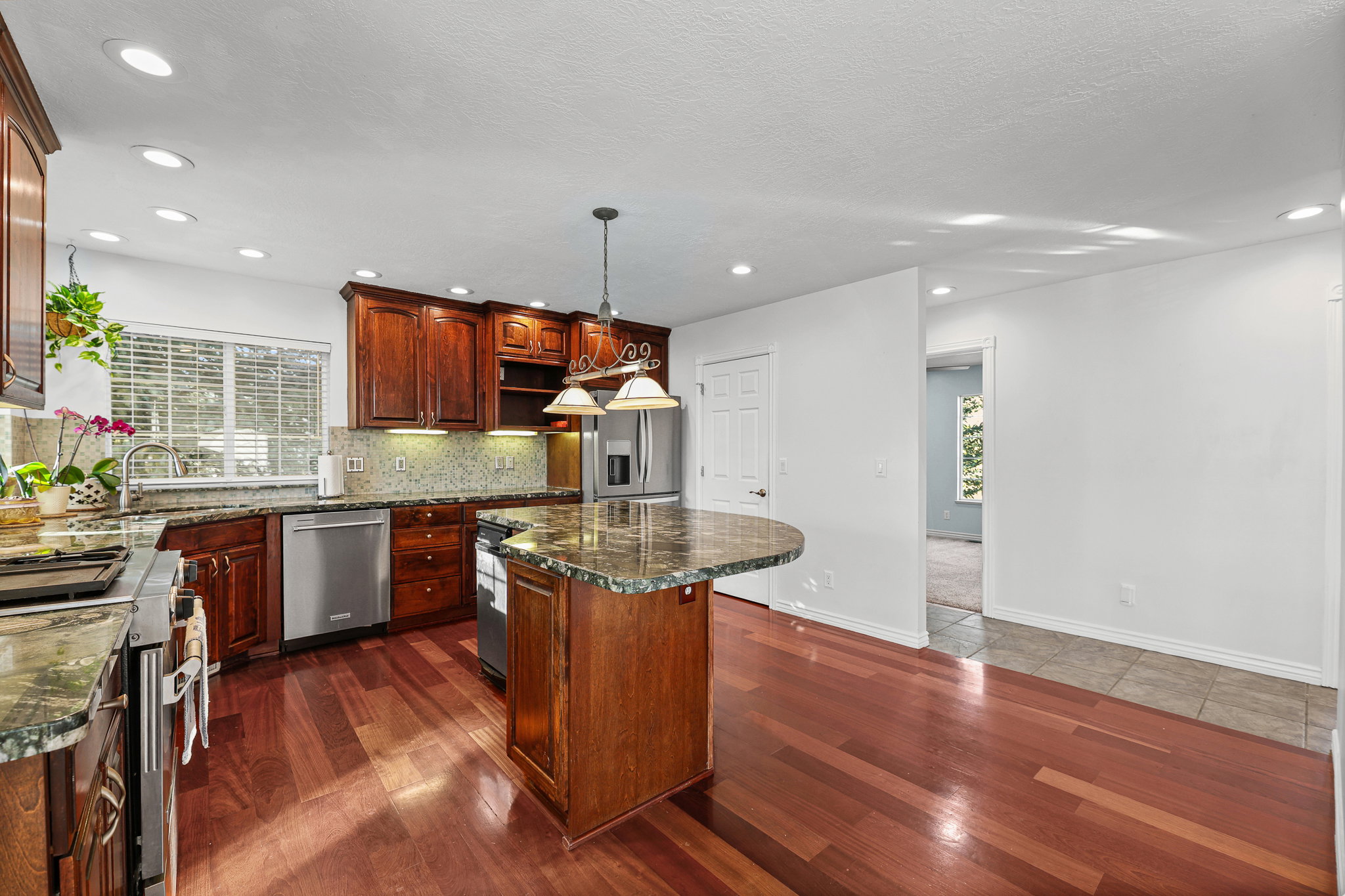 Kitchen featuring wood-finish flooring, recessed lighting, and a center island with countertop seating