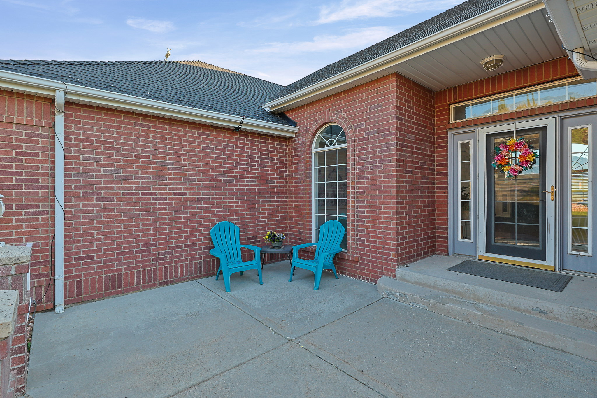 Brick exterior with a dark shingle roof and white gutters