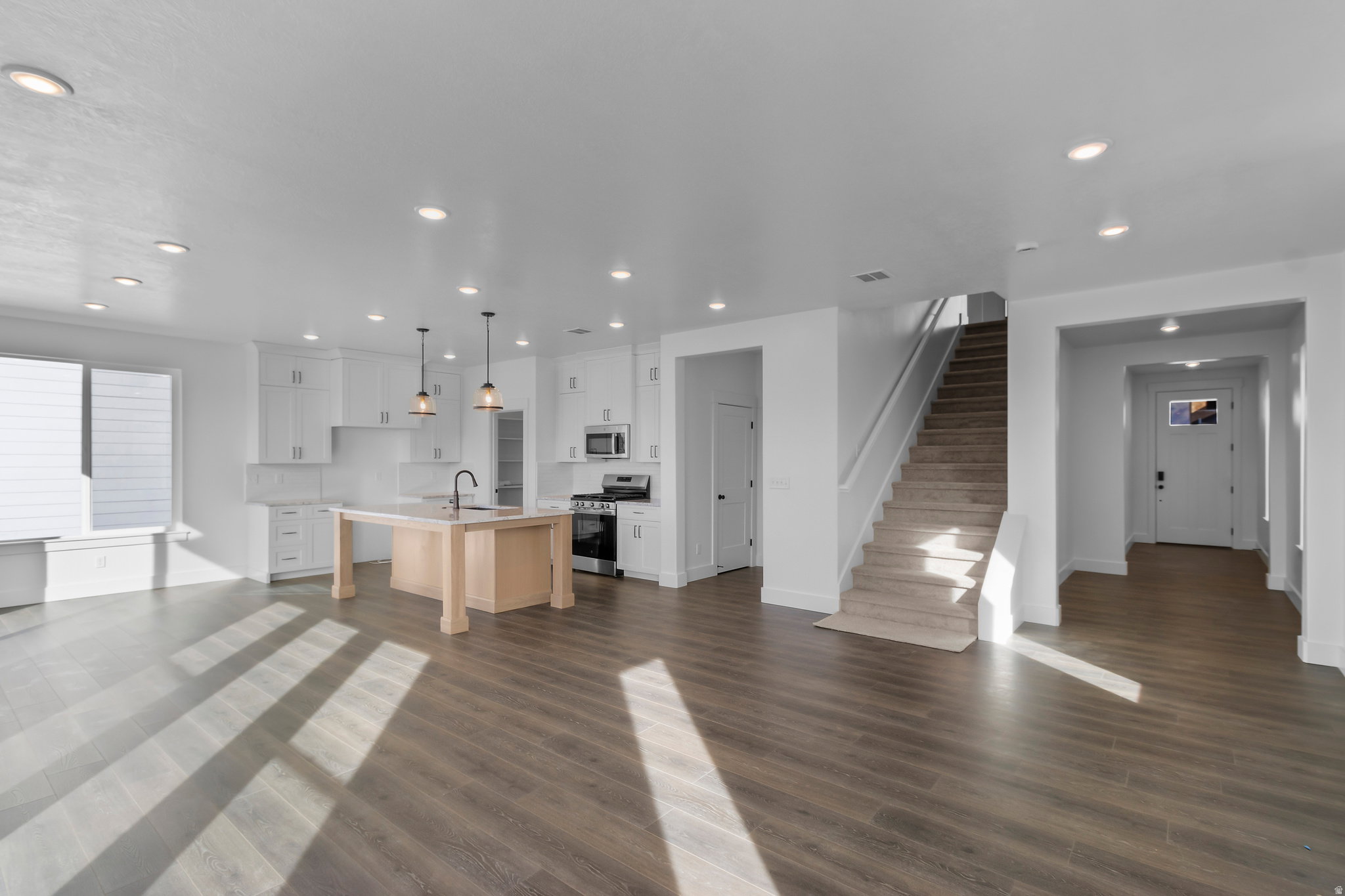 Open concept living area featuring wood-finish flooring, recessed lighting, and a modern kitchen