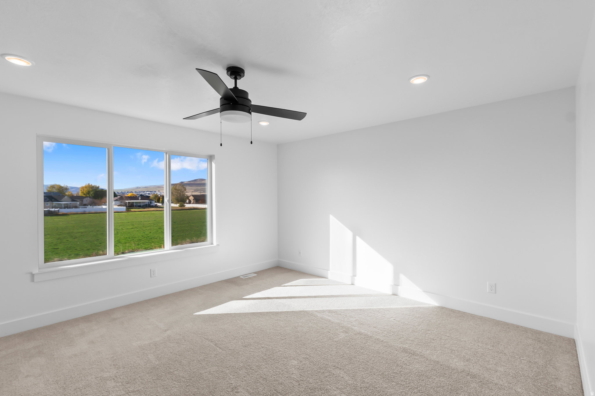 Bright room featuring a three-panel window, recessed lighting, and a contemporary ceiling fan