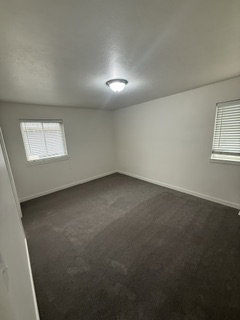 Neutral wall tones complement the dark gray carpeting