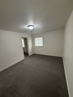 Room featuring neutral wall finishes and dark gray carpeting
