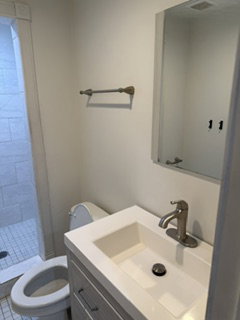 Bathroom featuring a white integrated sink and countertop, brushed nickel faucet, and a mirrored vanity
