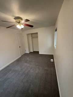 Neutral-toned room featuring dark gray carpeting and light-colored walls