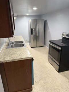 Kitchen featuring a double basin stainless steel sink, speckled countertop, and recessed lighting
