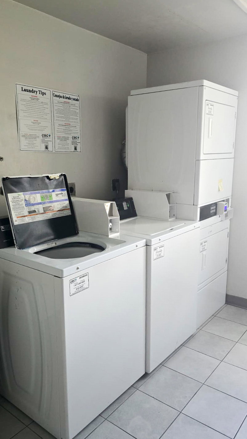 Dedicated laundry area featuring multiple white washers and dryers