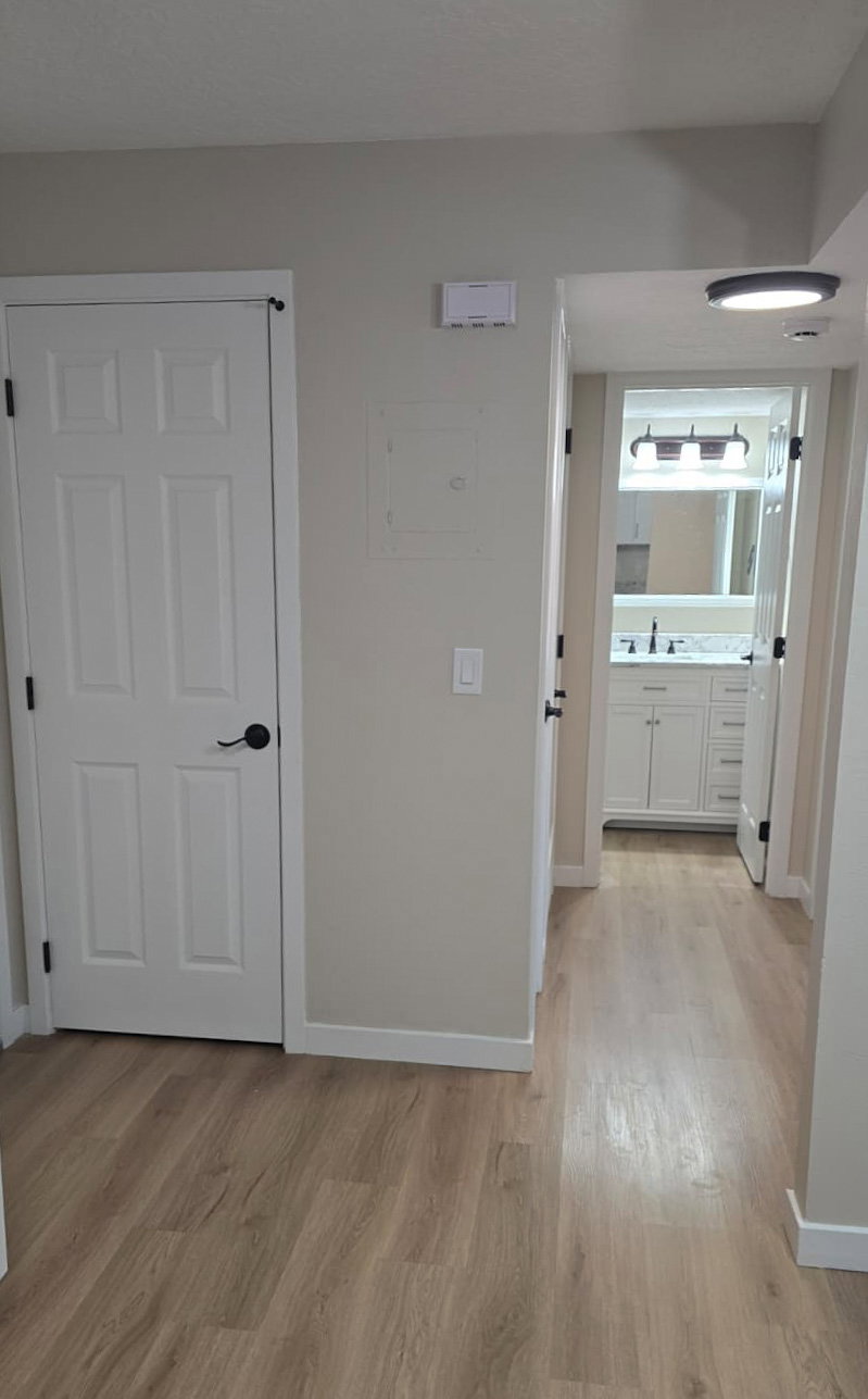Entryway featuring light wood-finish flooring, white paneled doors, and neutral wall tones