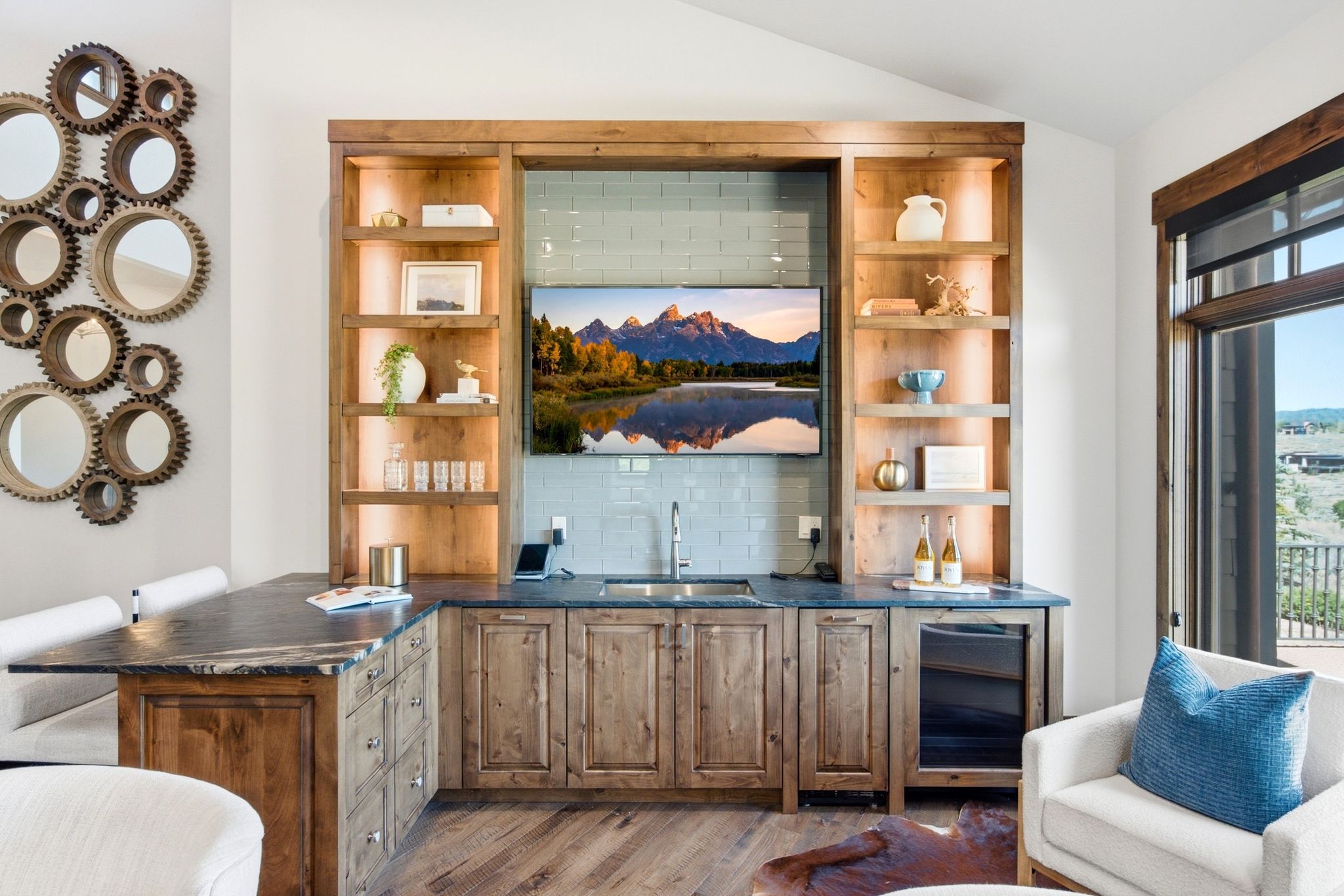 Built-in entertainment center featuring wood-finish cabinetry, integrated shelving with accent lighting, a beverage cooler, and a wet bar with a tiled backsplash