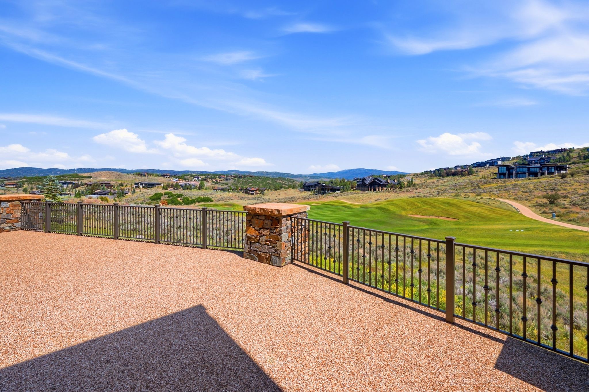 Spacious outdoor patio with aggregate surfacing and decorative metal railings