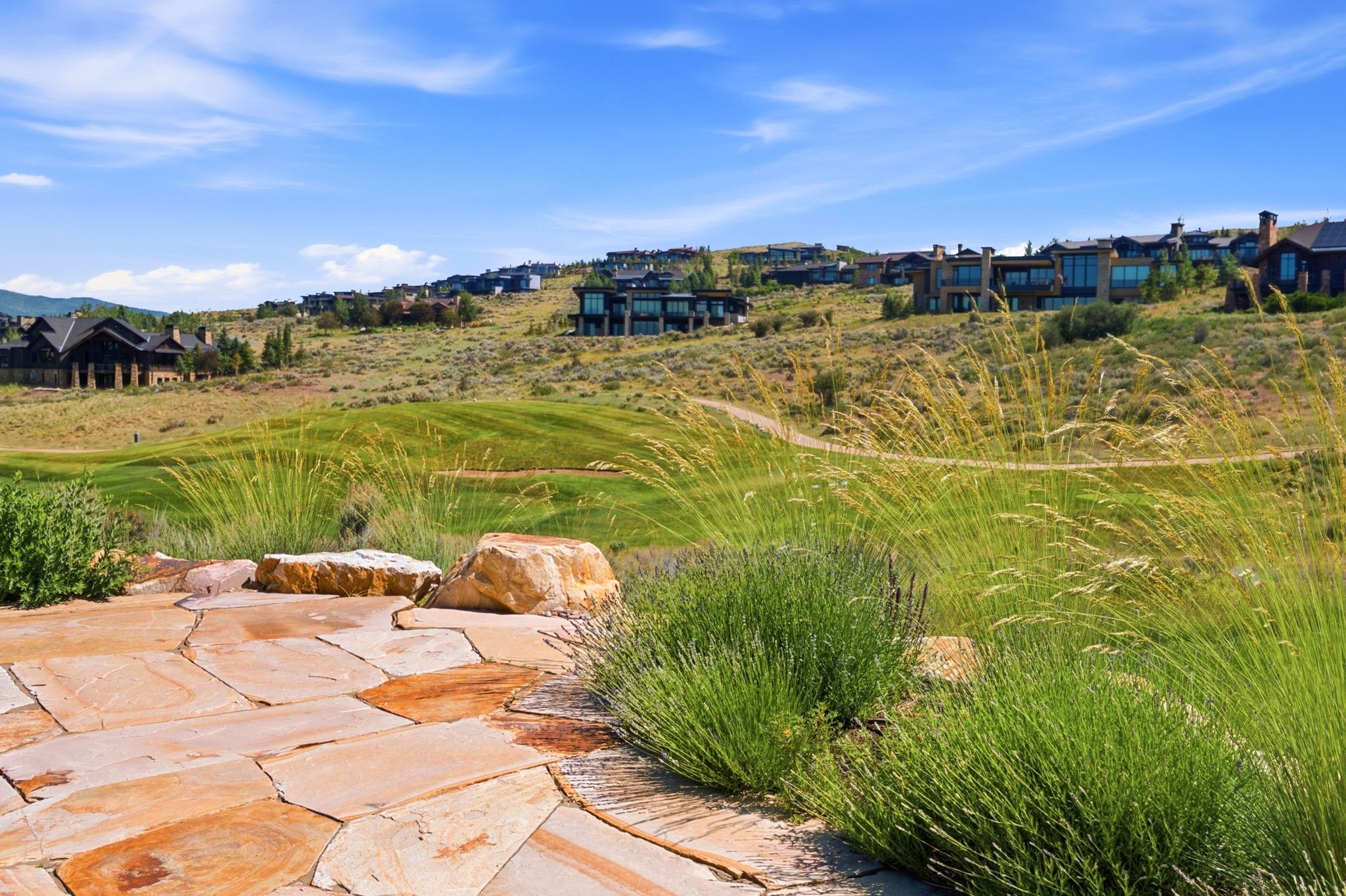 Natural stone patio featuring irregular flagstone pavers and decorative boulders