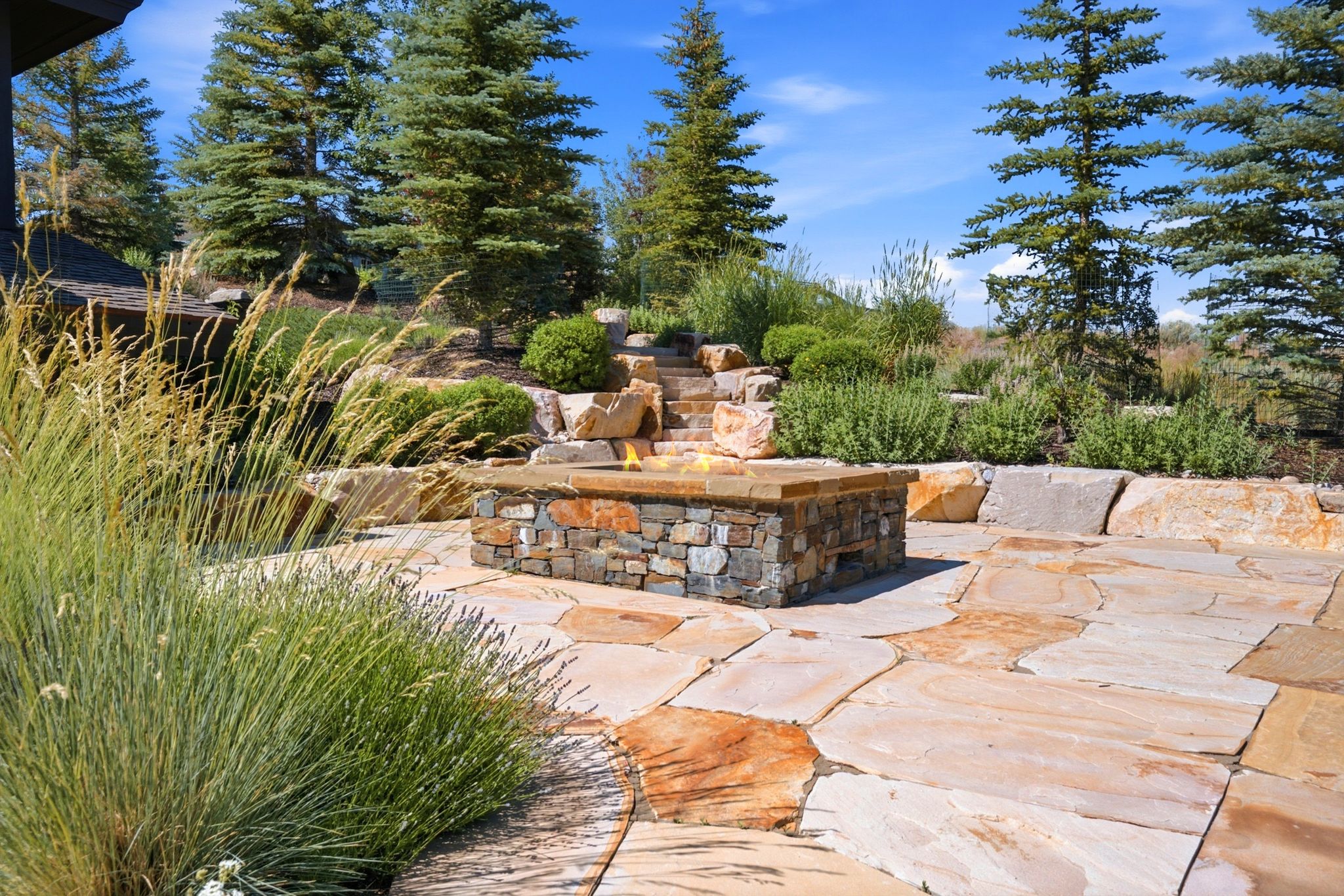 Stone patio featuring a built-in fire pit with stone surround and cap