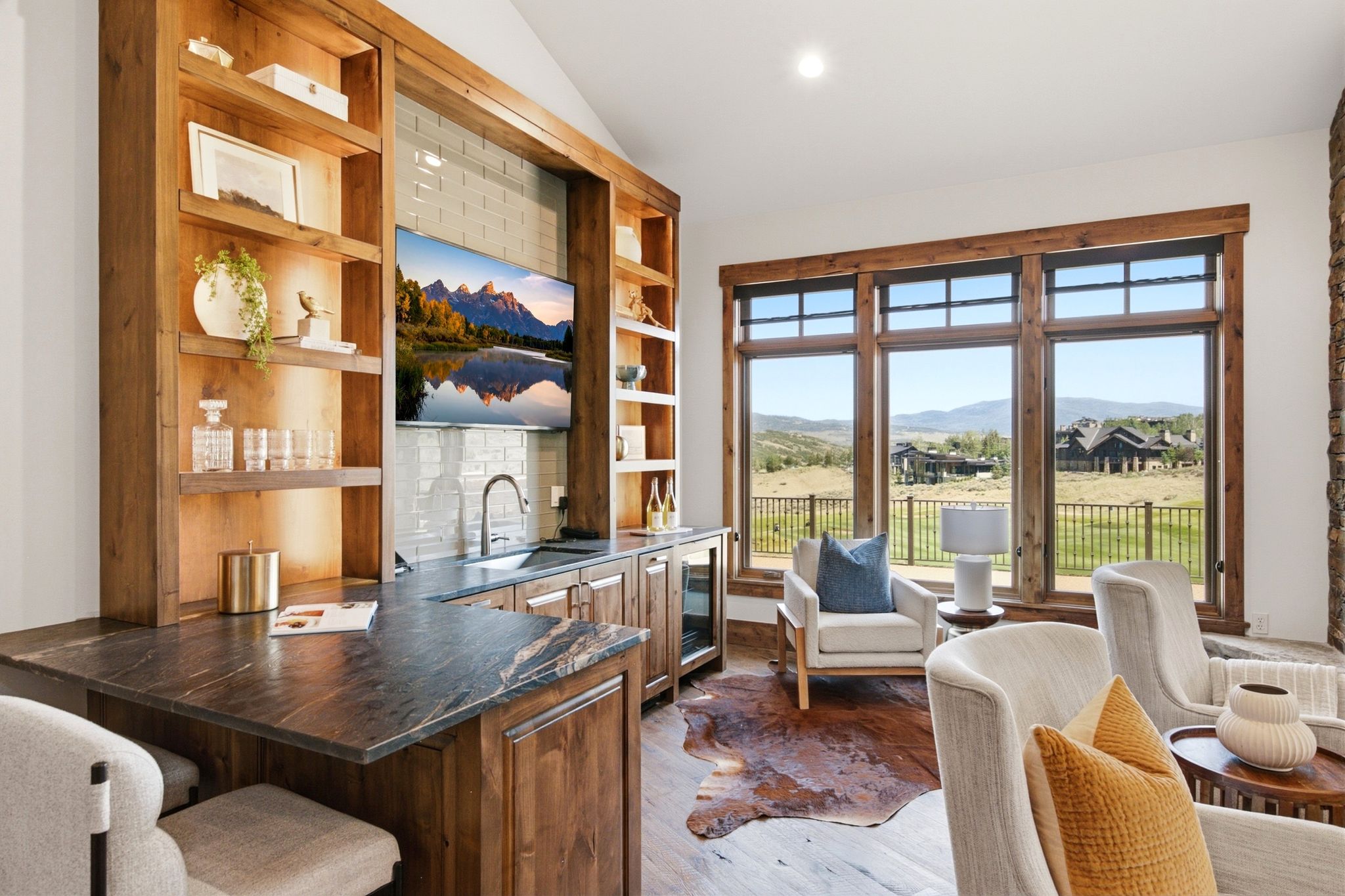 Integrated wet bar with wood-finish cabinetry, stone countertops, and subway tile backsplash