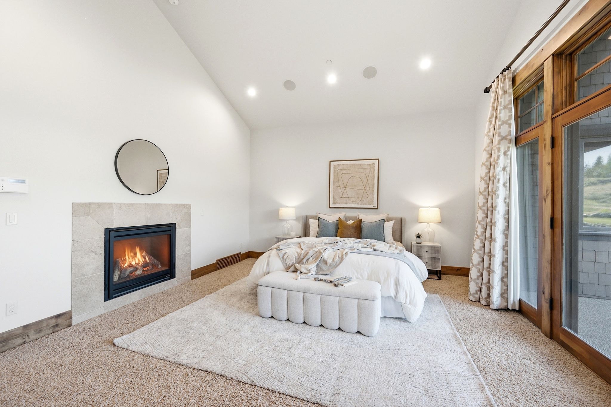 Vaulted ceiling bedroom with a stone-surround fireplace