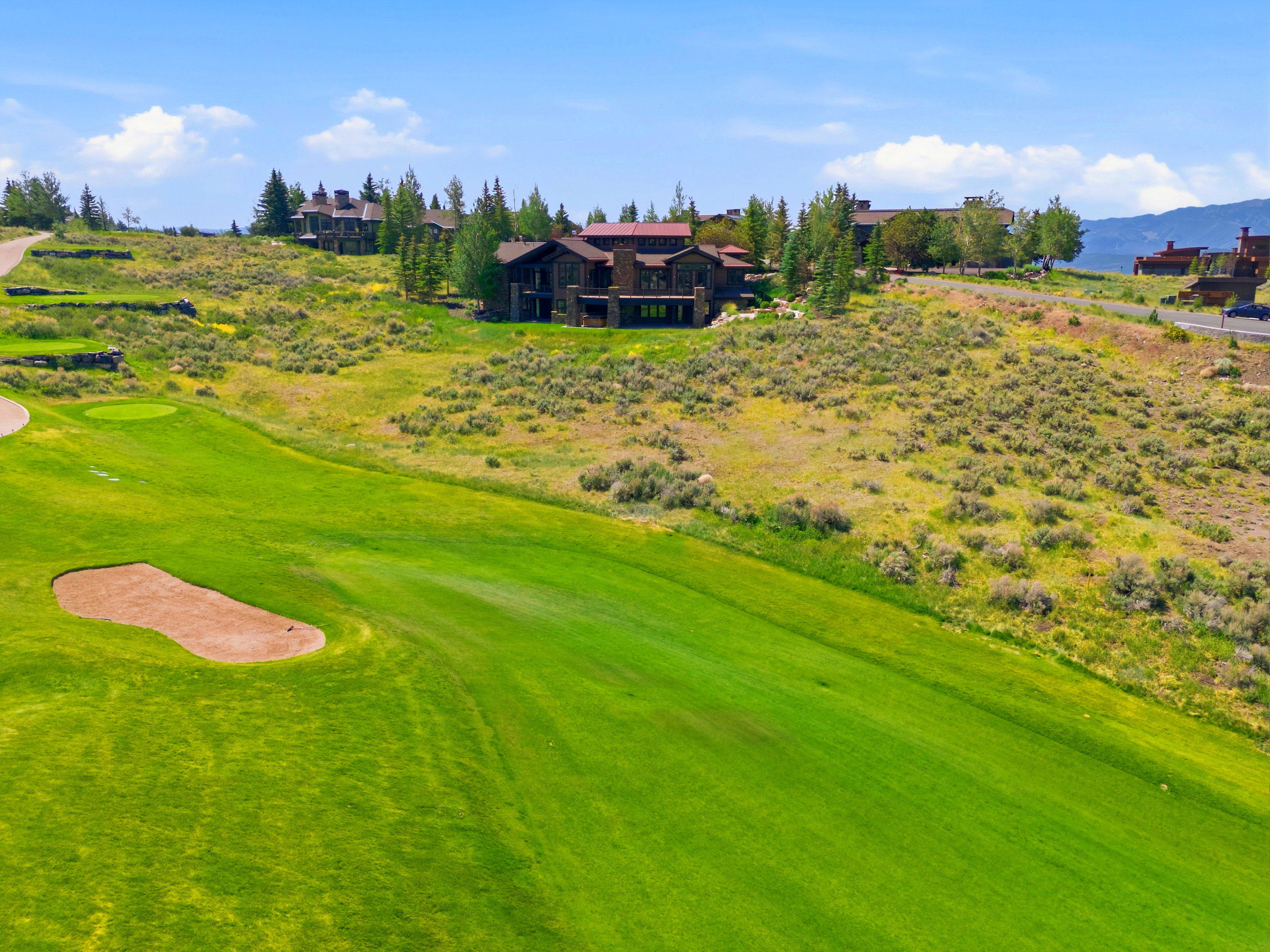Expansive golf course featuring a green fairway and sand trap