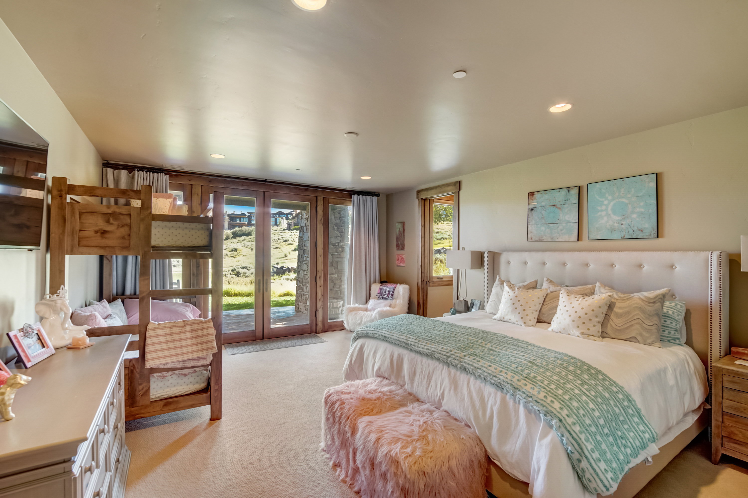 Spacious room featuring a plush upholstered headboard, recessed lighting, and carpet flooring