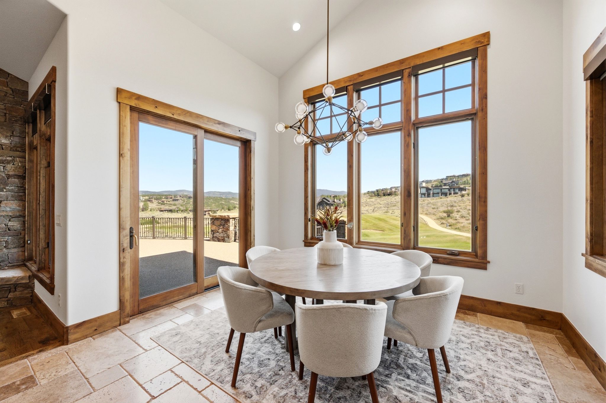 Dining area featuring a vaulted ceiling and a contemporary chandelier