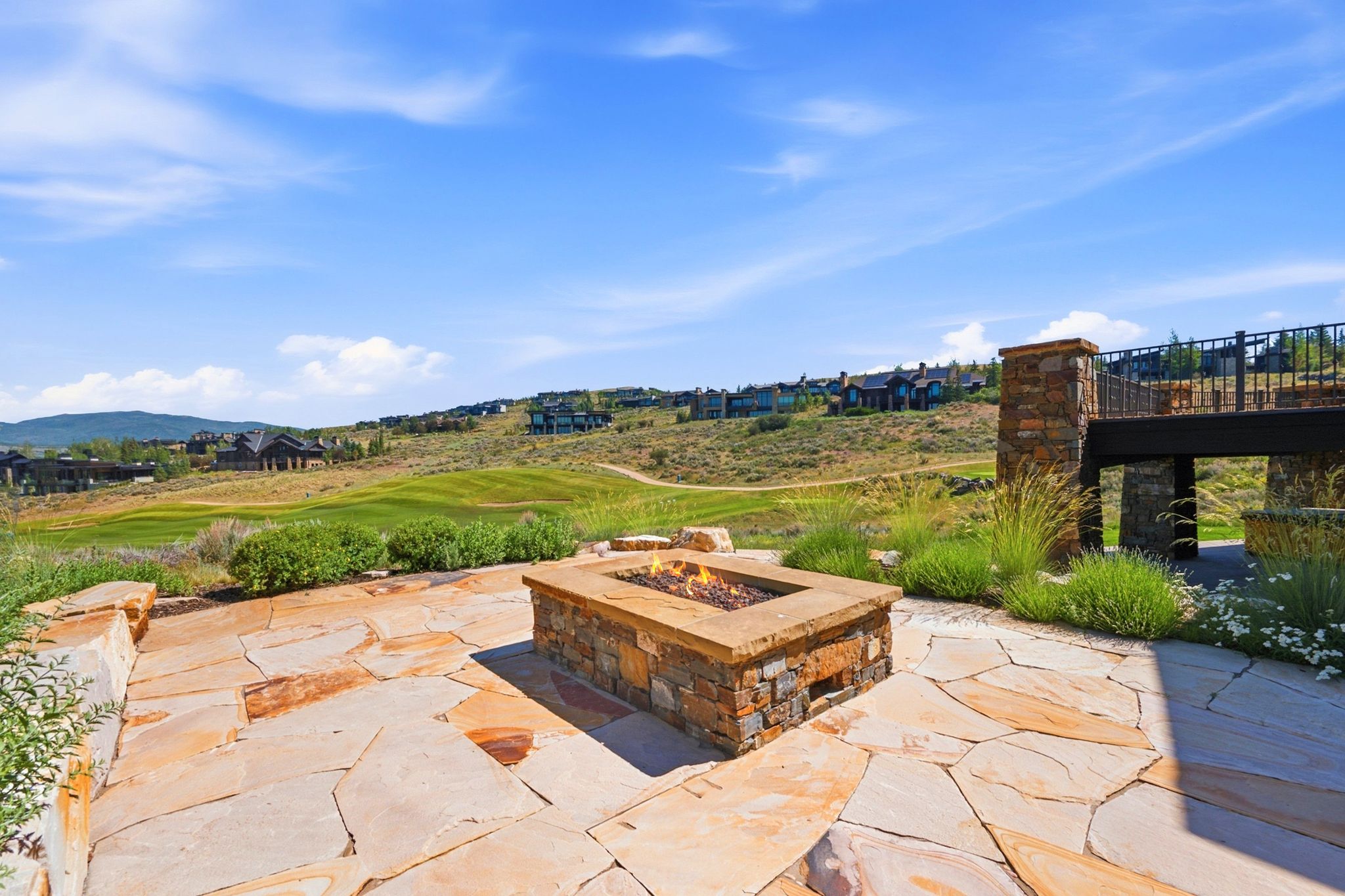 Expansive flagstone patio with a built-in stone fire pit