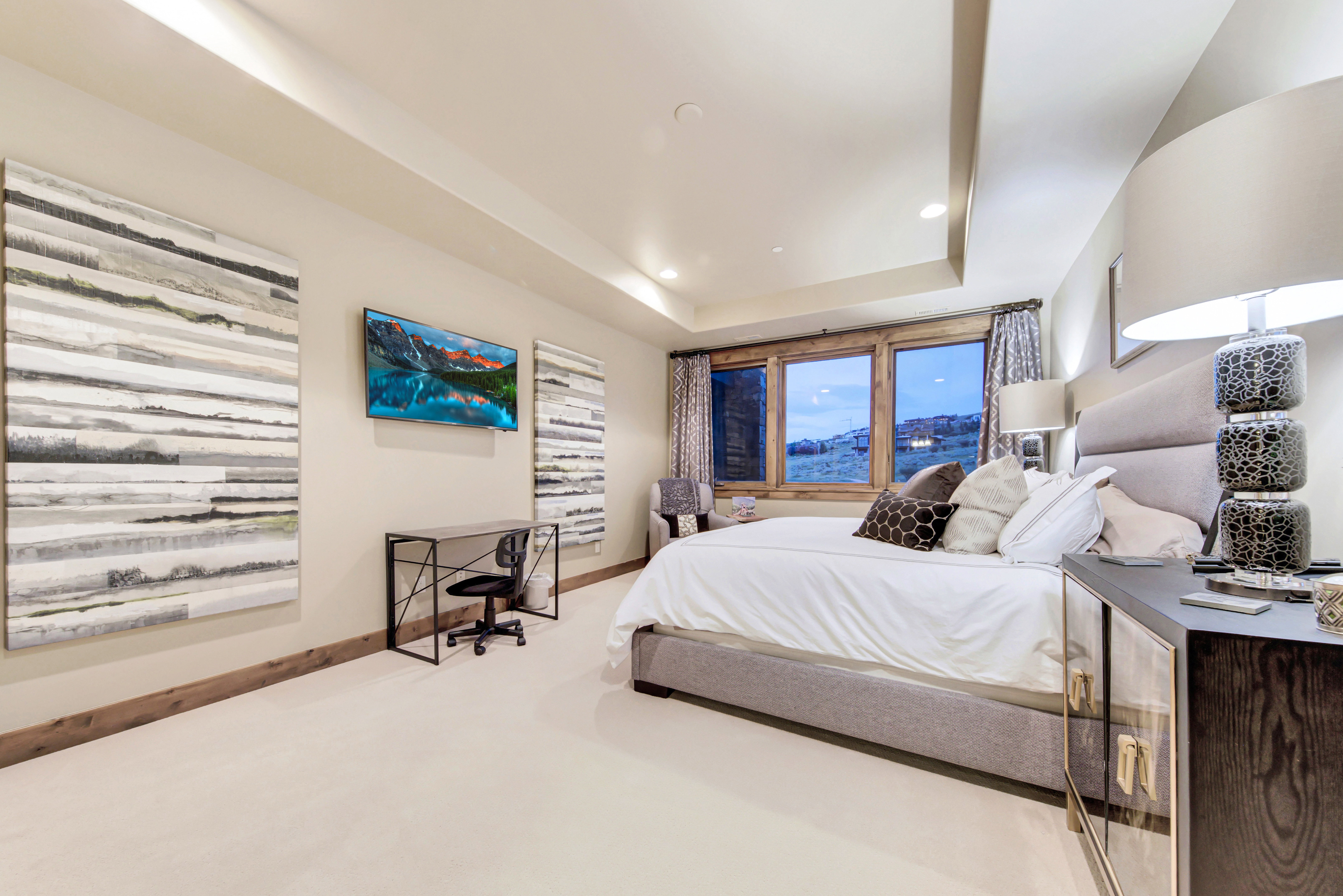 Spacious bedroom featuring recessed lighting, a tray ceiling, and a wall-mounted flat-screen television