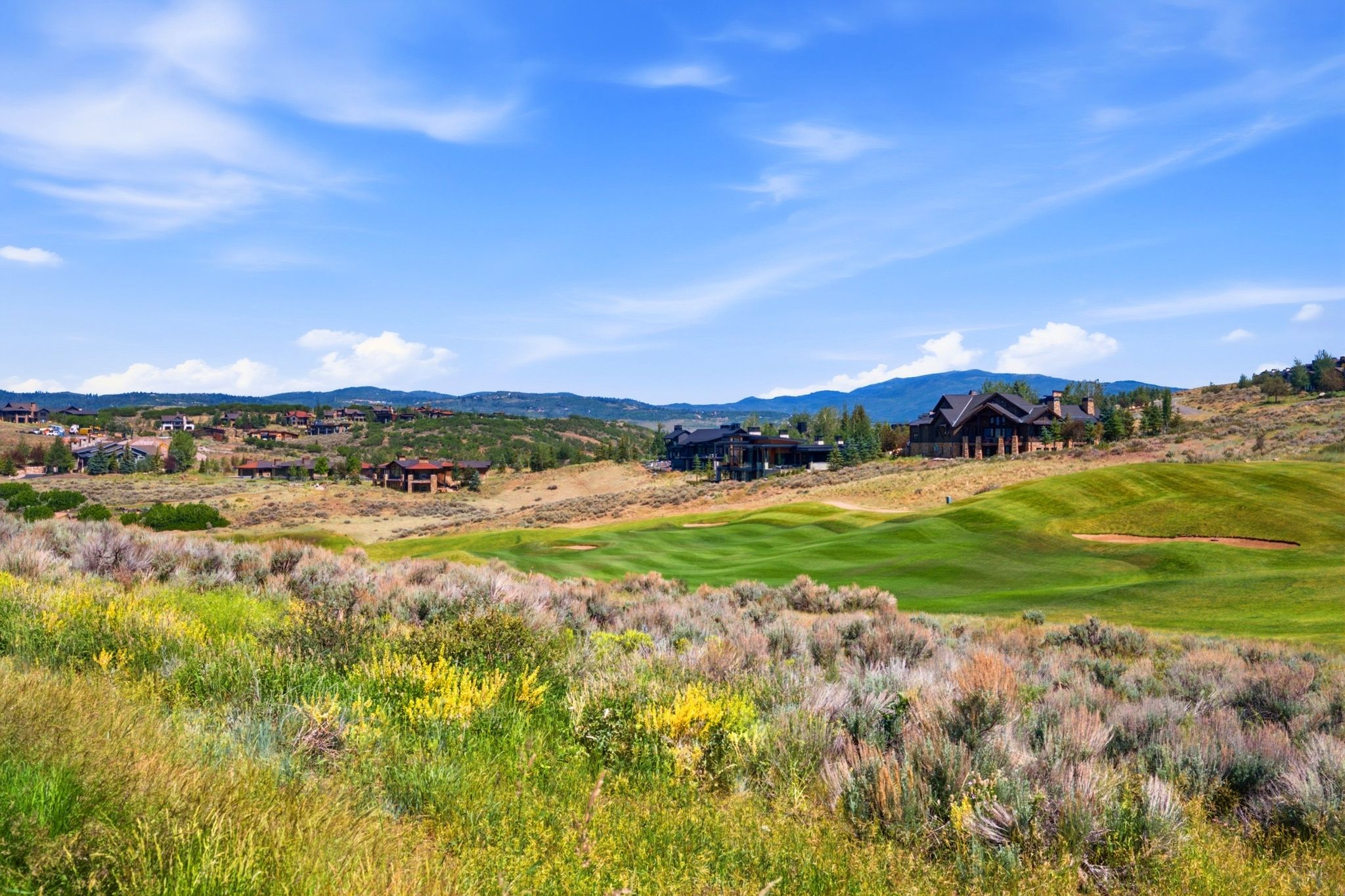Expansive golf course setting featuring manicured greens and surrounding natural terrain