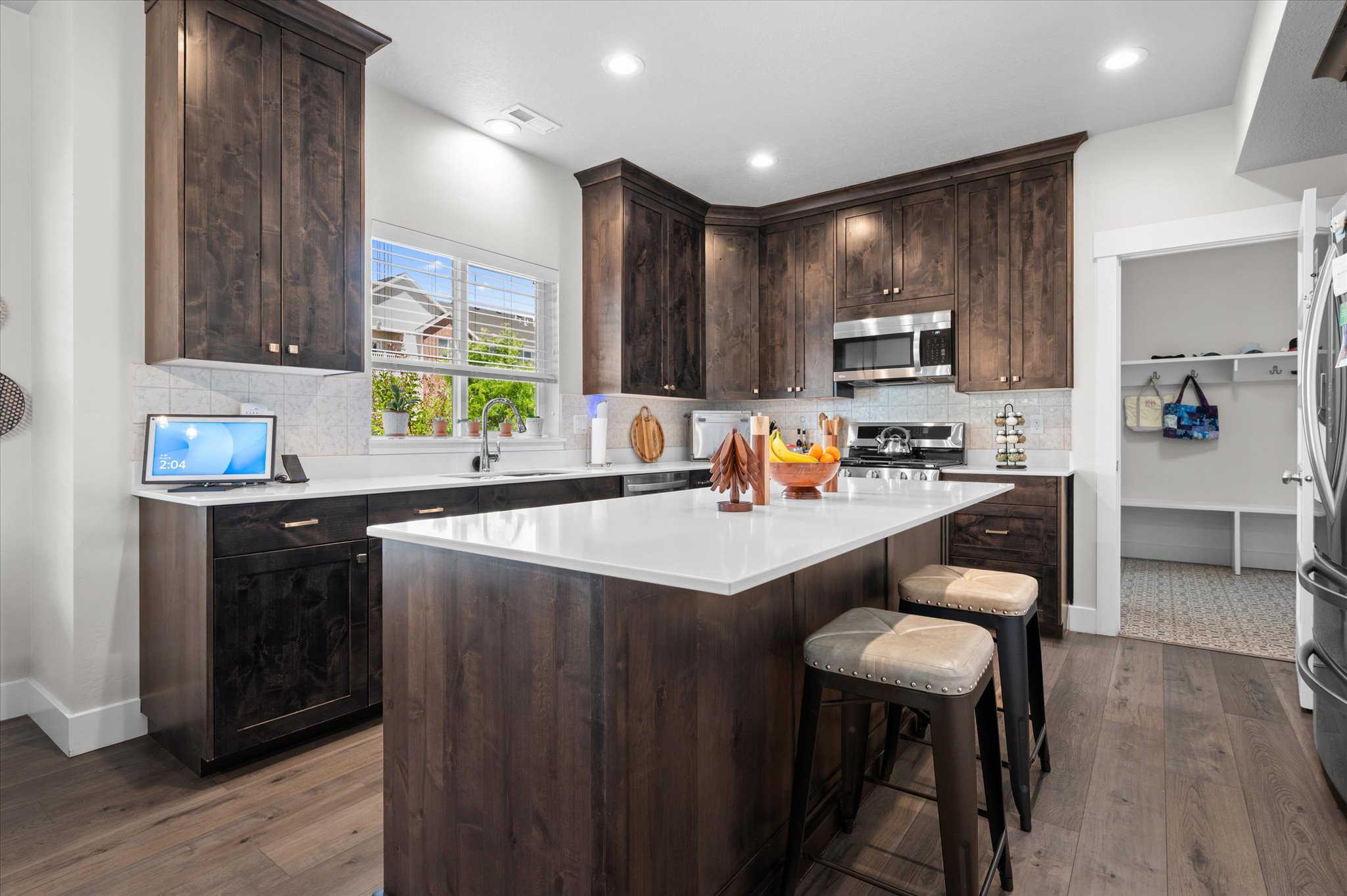 Kitchen featuring dark wood-finish cabinetry, white countertops, and a white subway tile backsplash