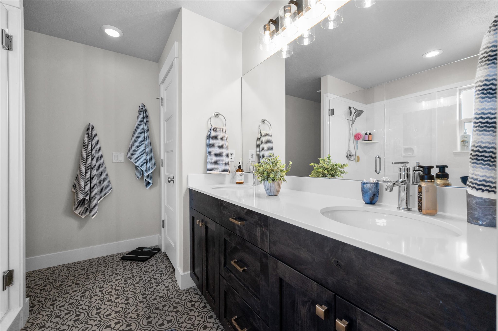 Primary Owner Bathroom featuring a dual vanity with dark wood-finish cabinetry, white countertops, and undermount sinks