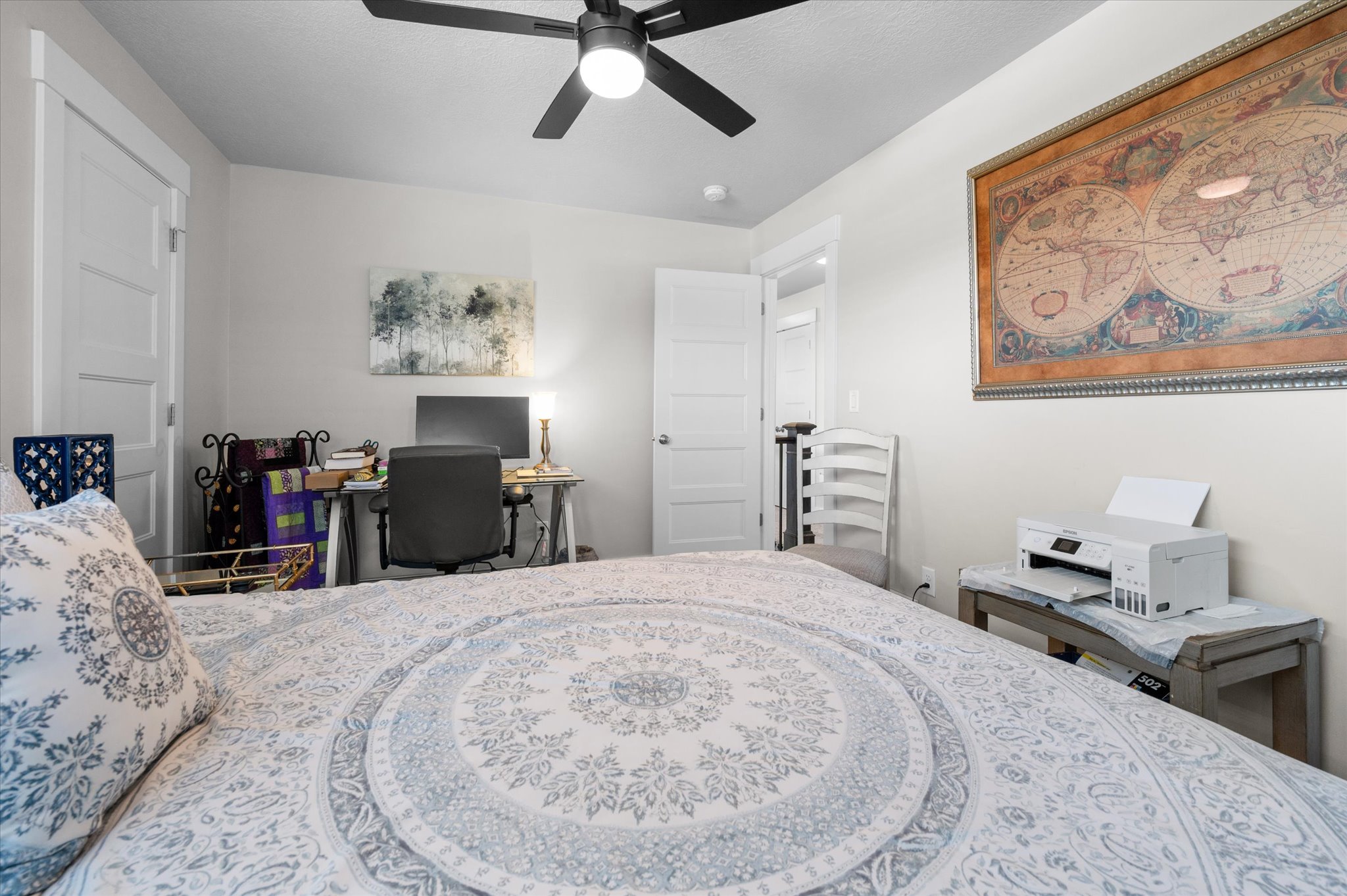 Neutral wall paint with crisp white trim, modern ceiling fan with integrated lighting, and a white paneled door