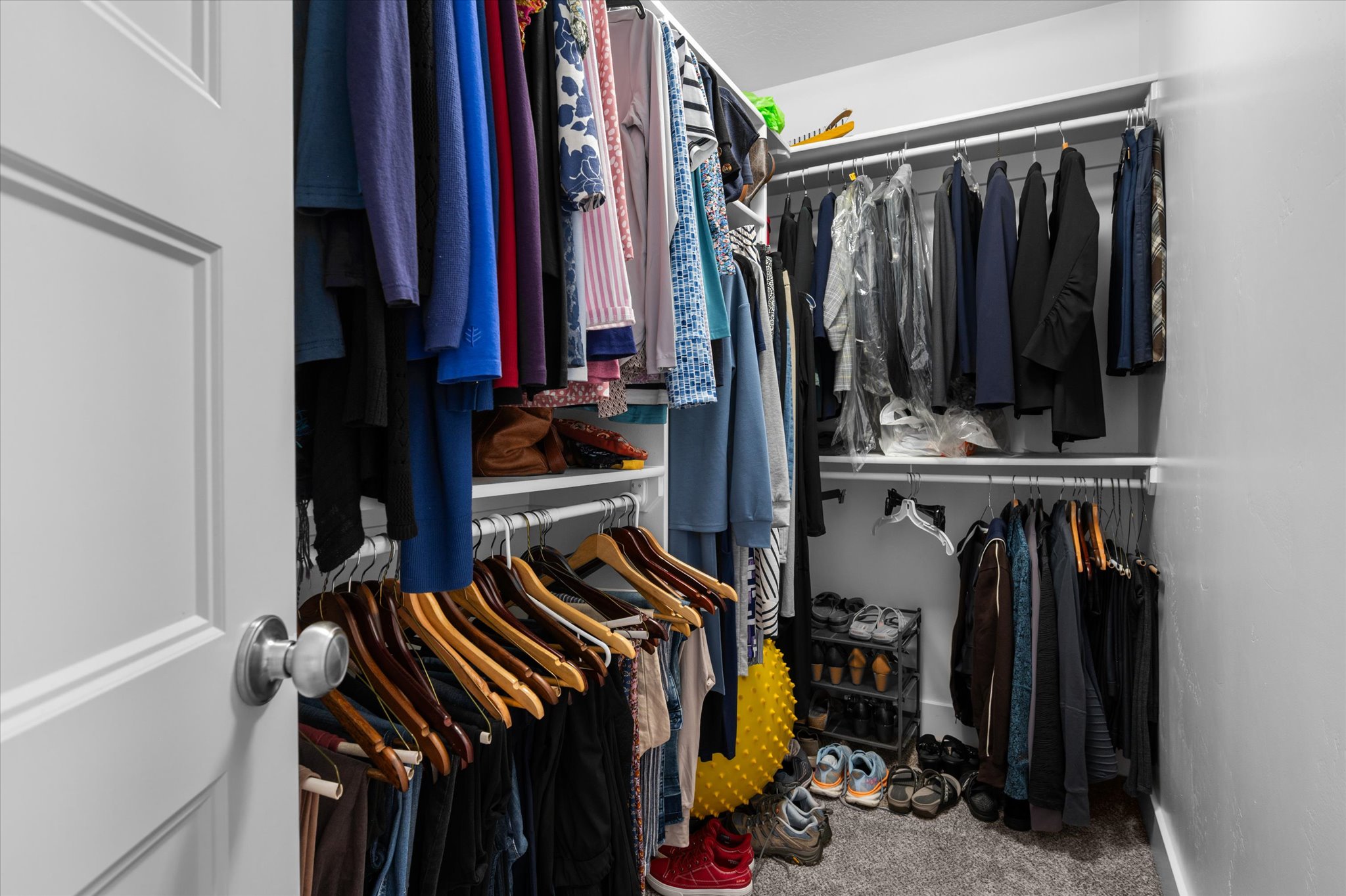 Primary Owner Walk-in closet featuring white wire shelving, multiple hanging rods, and carpet flooring