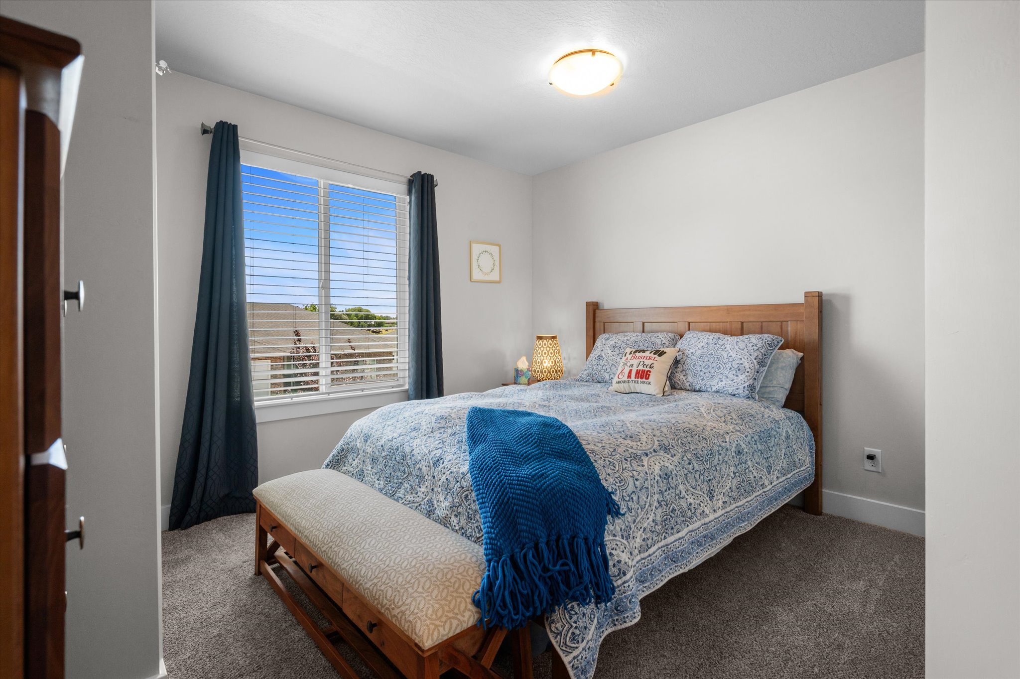 Bright room featuring a large window with blinds and dark drapery panels