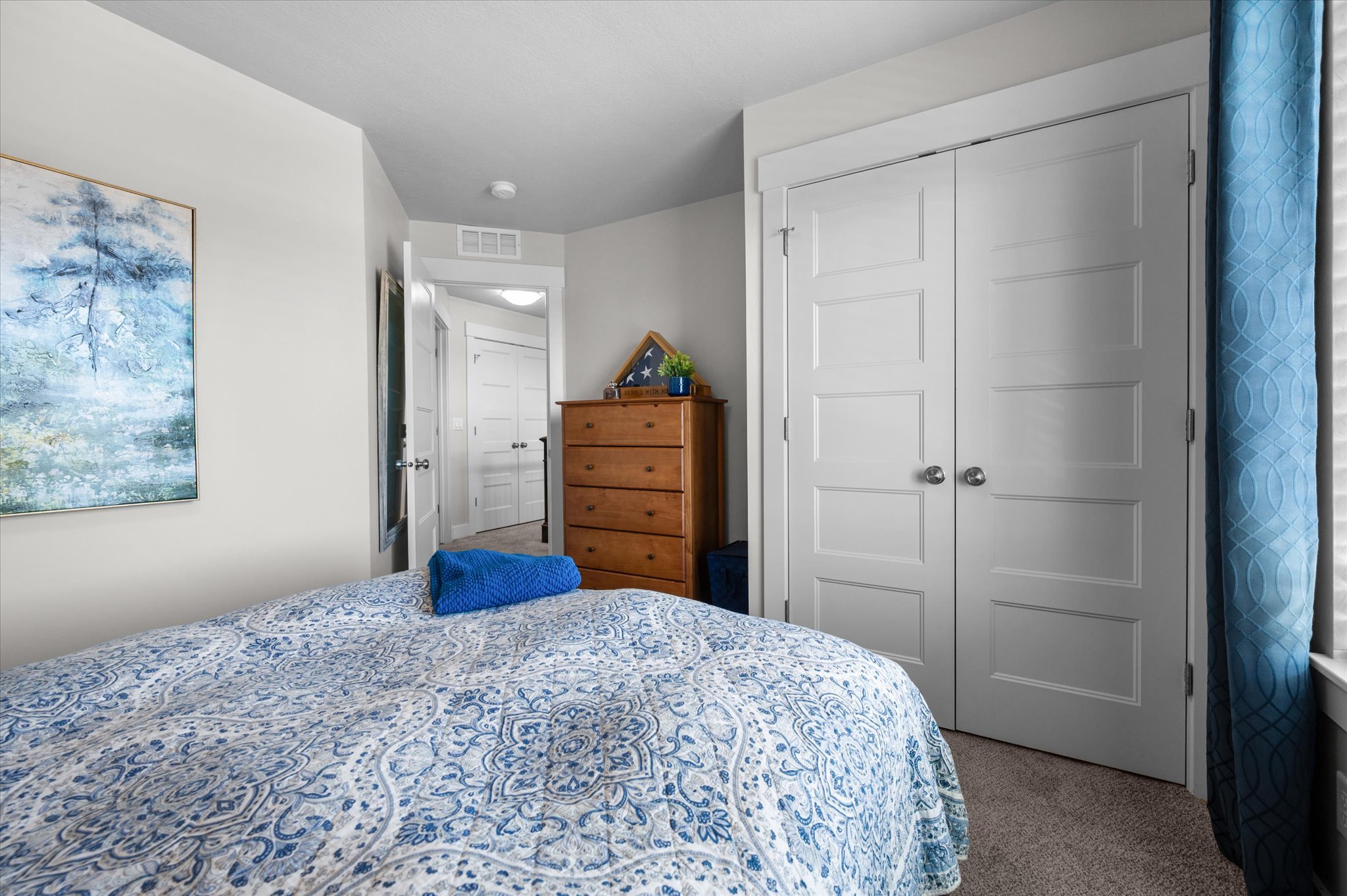 Bedroom featuring light-toned walls, a closet with white paneled bifold doors, and neutral-toned carpeting