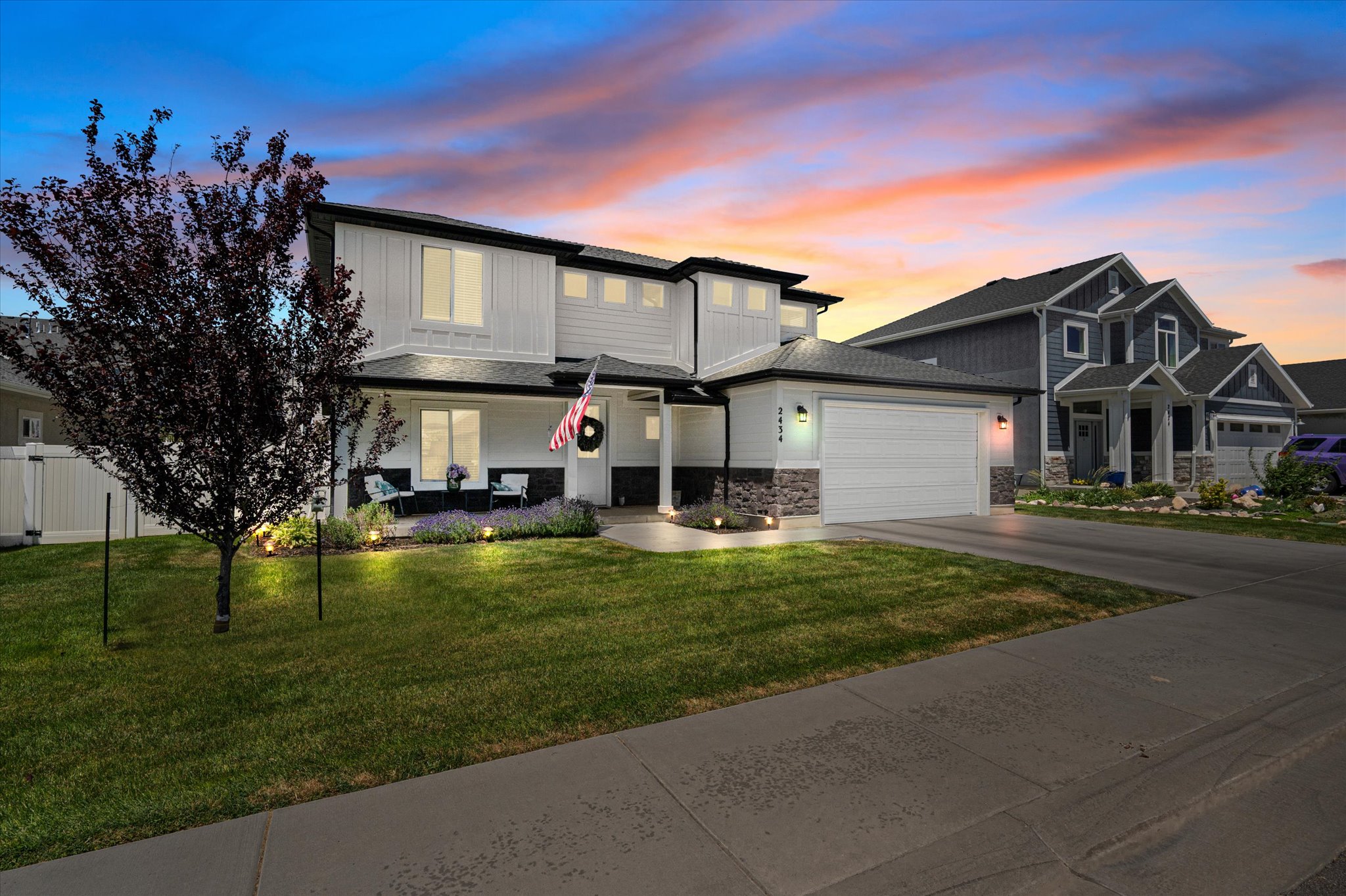 Contemporary two-story residence featuring white siding and dark trim accents